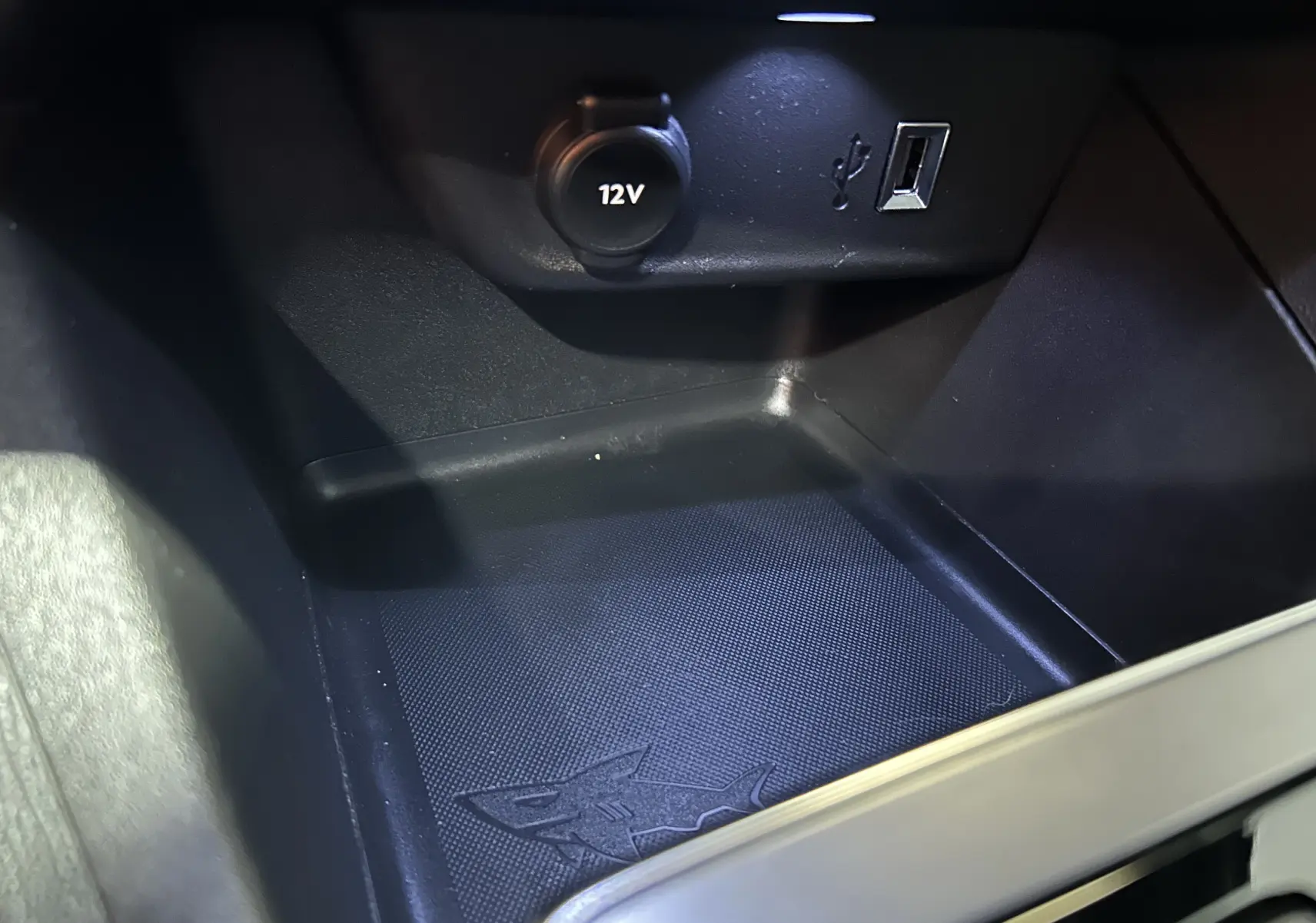 Gros plan sur la prise 12V et port USB dans le rangement central noir de l’Opel Mokka GS Line 2022.