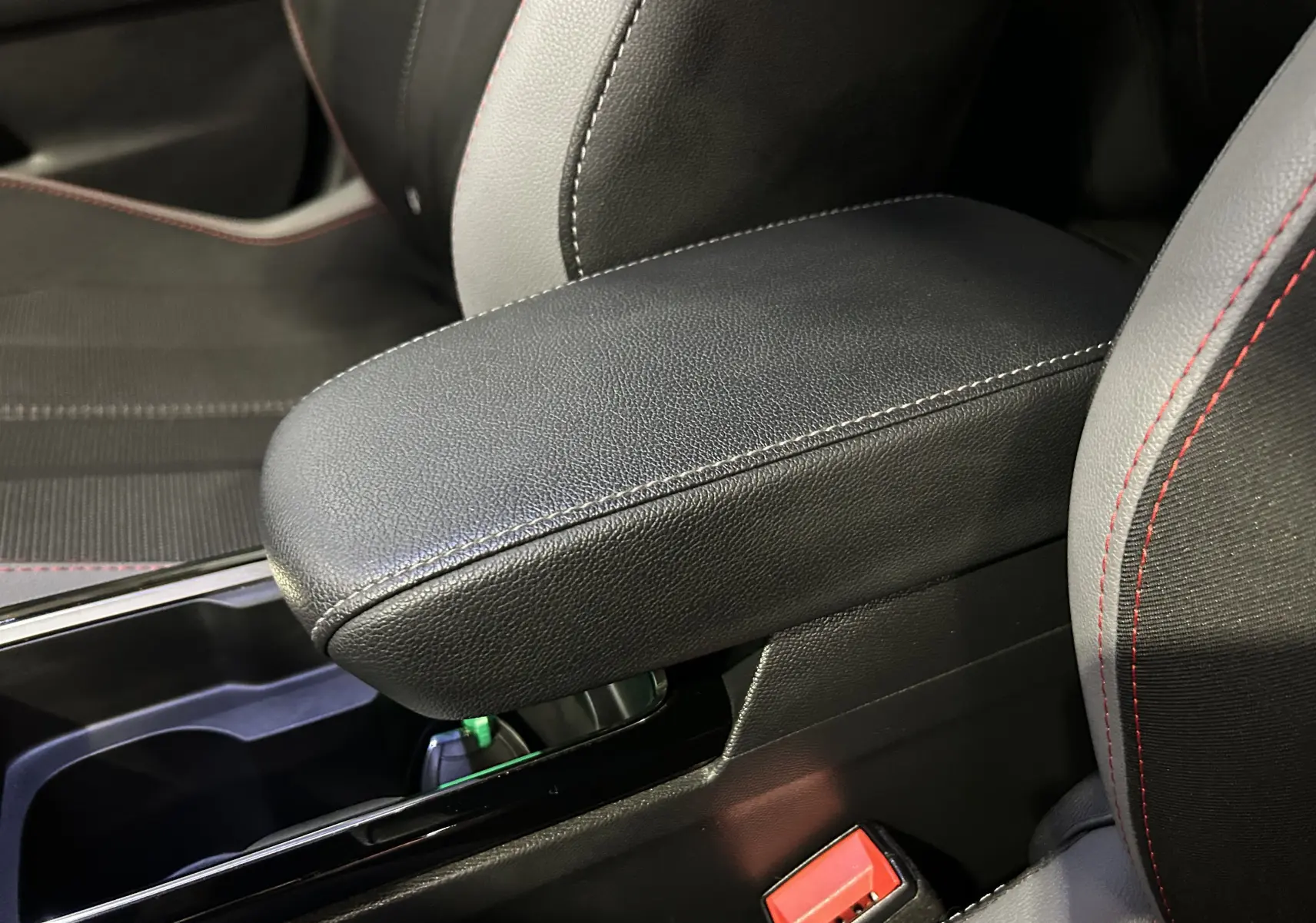 Détail de l'accoudoir central en cuir noir avec surpiqûres blanches, entre les sièges avant du Opel Mokka GS Line 2022.