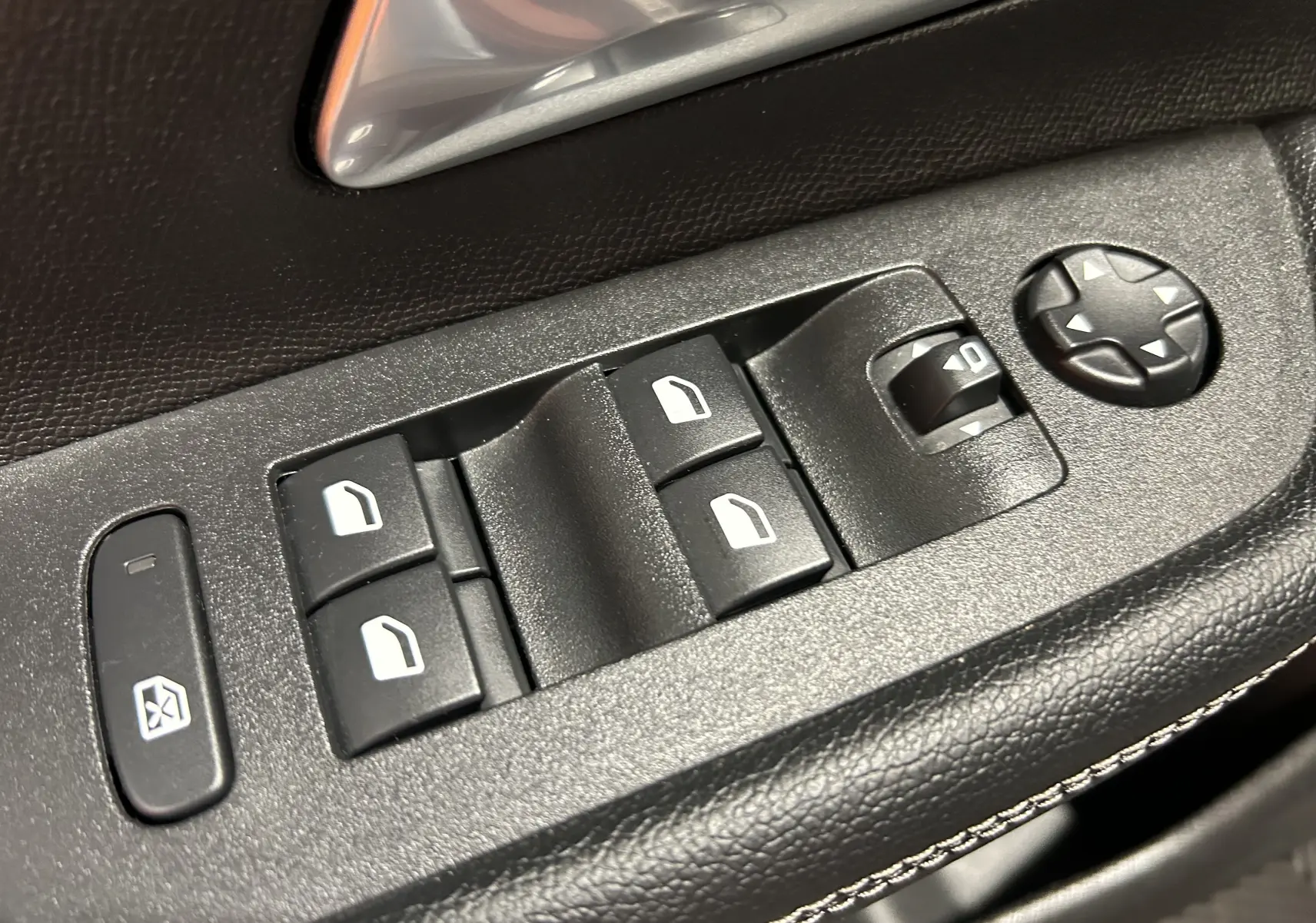 Gros plan sur les commandes des vitres électriques et réglage des rétroviseurs côté conducteur d’un Opel Mokka GS Line 2022.