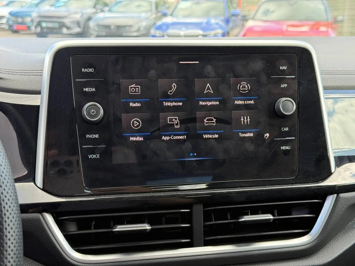 Écran tactile central du tableau de bord du Volkswagen T-Roc, avec menu multimédia affiché, intérieur noir.