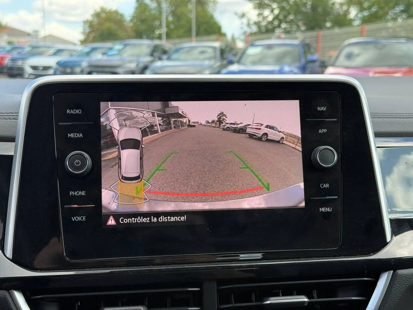 Écran tactile intérieur montrant la caméra de recul avec vue arrière et lignes de guidage vertes et rouges.