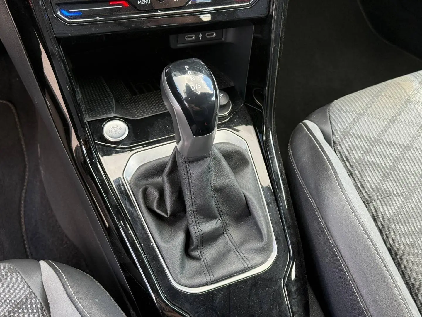 Le levier de vitesse automatique noir et gris du Volkswagen T-Roc 2025, avec sellerie tissu et cuir gris visible.