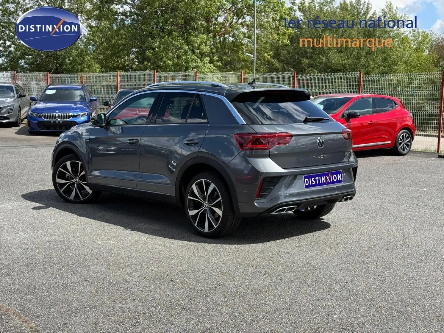 Volkswagen T-Roc gris Indium métallisé, vue 3/4 arrière droit, avec jantes alliage et sorties d’échappement chromées.