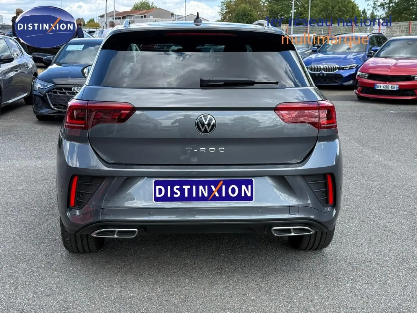 Vue arrière d'un Volkswagen T-Roc gris Indium métallisé avec double sortie d'échappement chromée et feux LED.