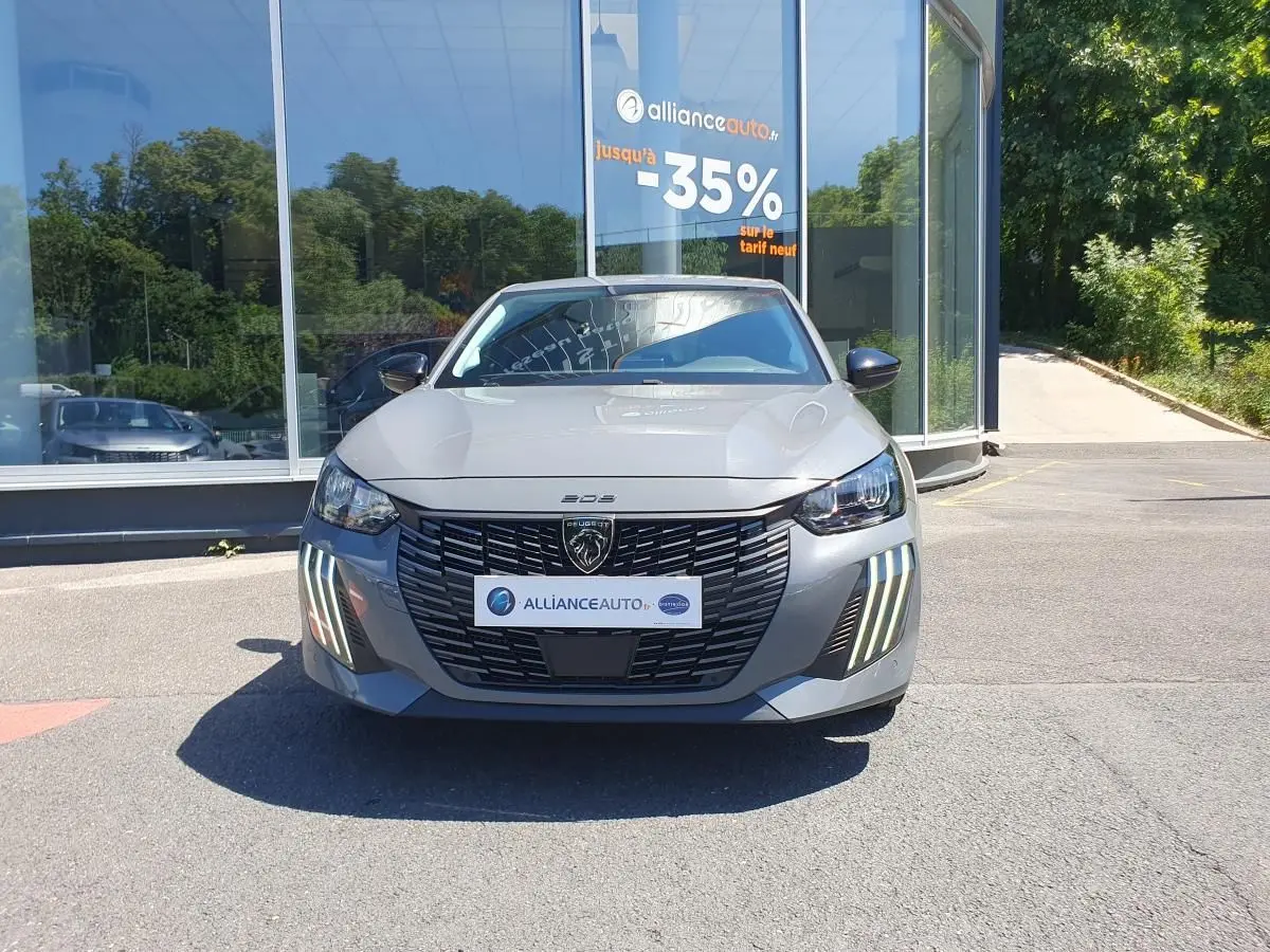 Peugeot 208 gris Sellenium vue de face, mettant en valeur la calandre noire et les feux diurnes LED en griffes.