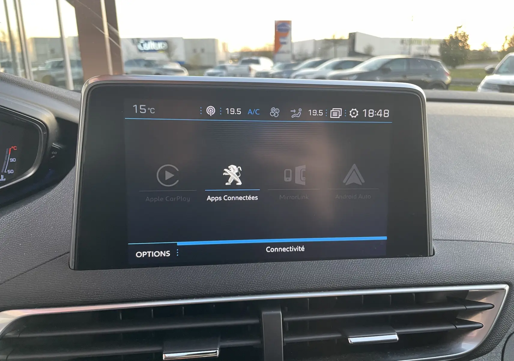 Écran tactile central du tableau de bord du Peugeot 3008 blanc nacré, affichant les options de connectivité.