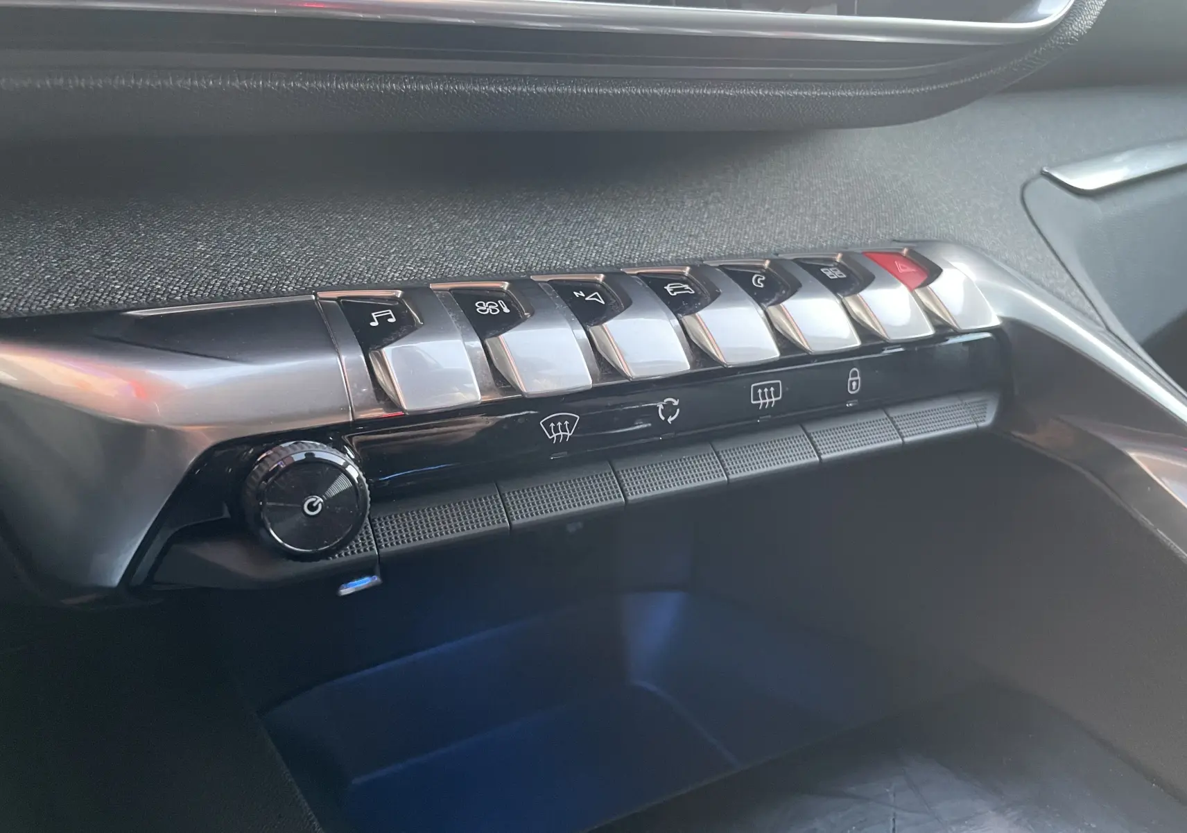 Gros plan sur la console centrale du Peugeot 3008 blanc nacré, montrant les boutons de commande et la molette de réglage.