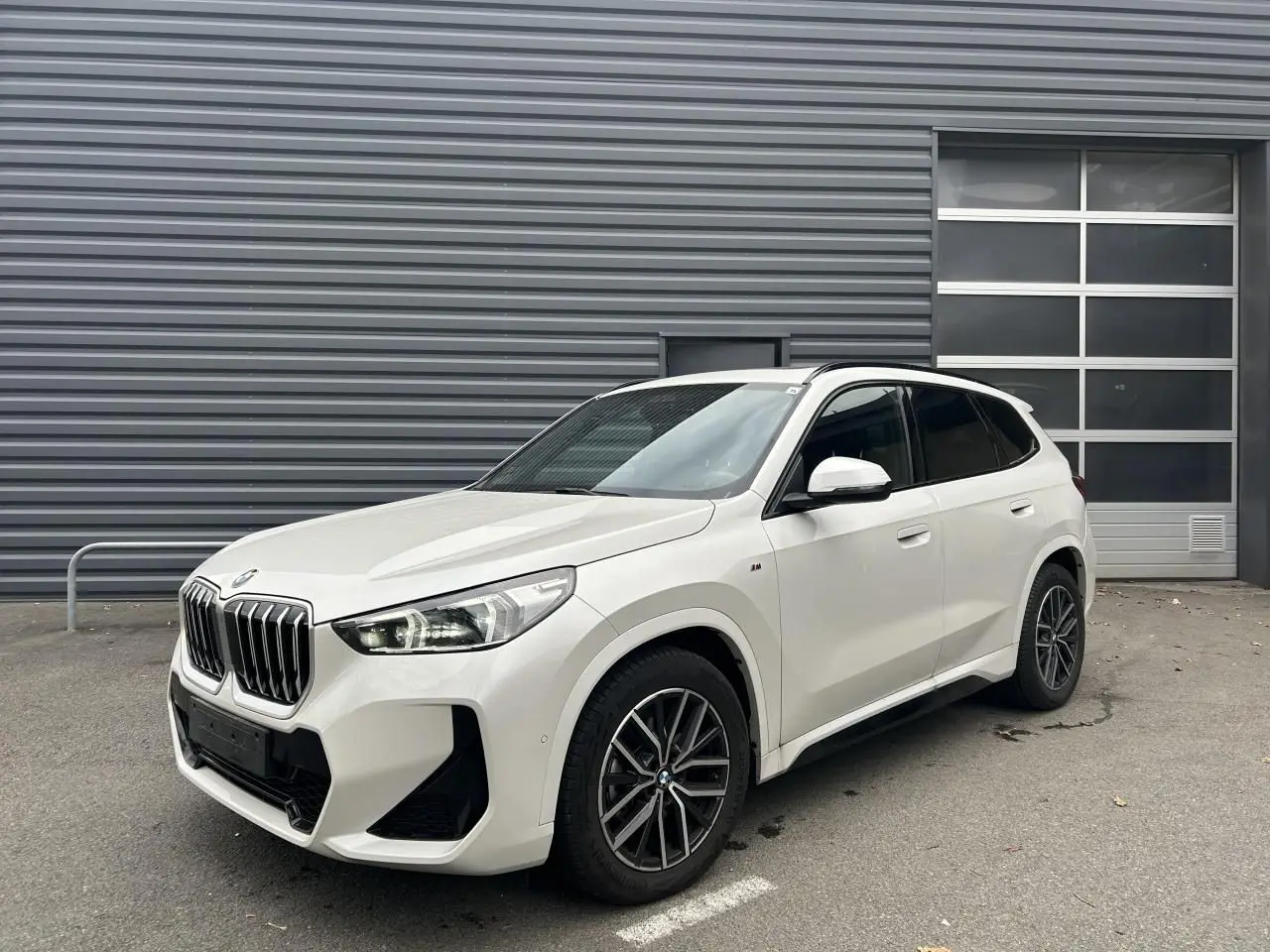 BMW X1 XDRIVE 20DA M-Sport noir vue 3/4 avant droit avec calandre imposante et jantes alliage bicolores