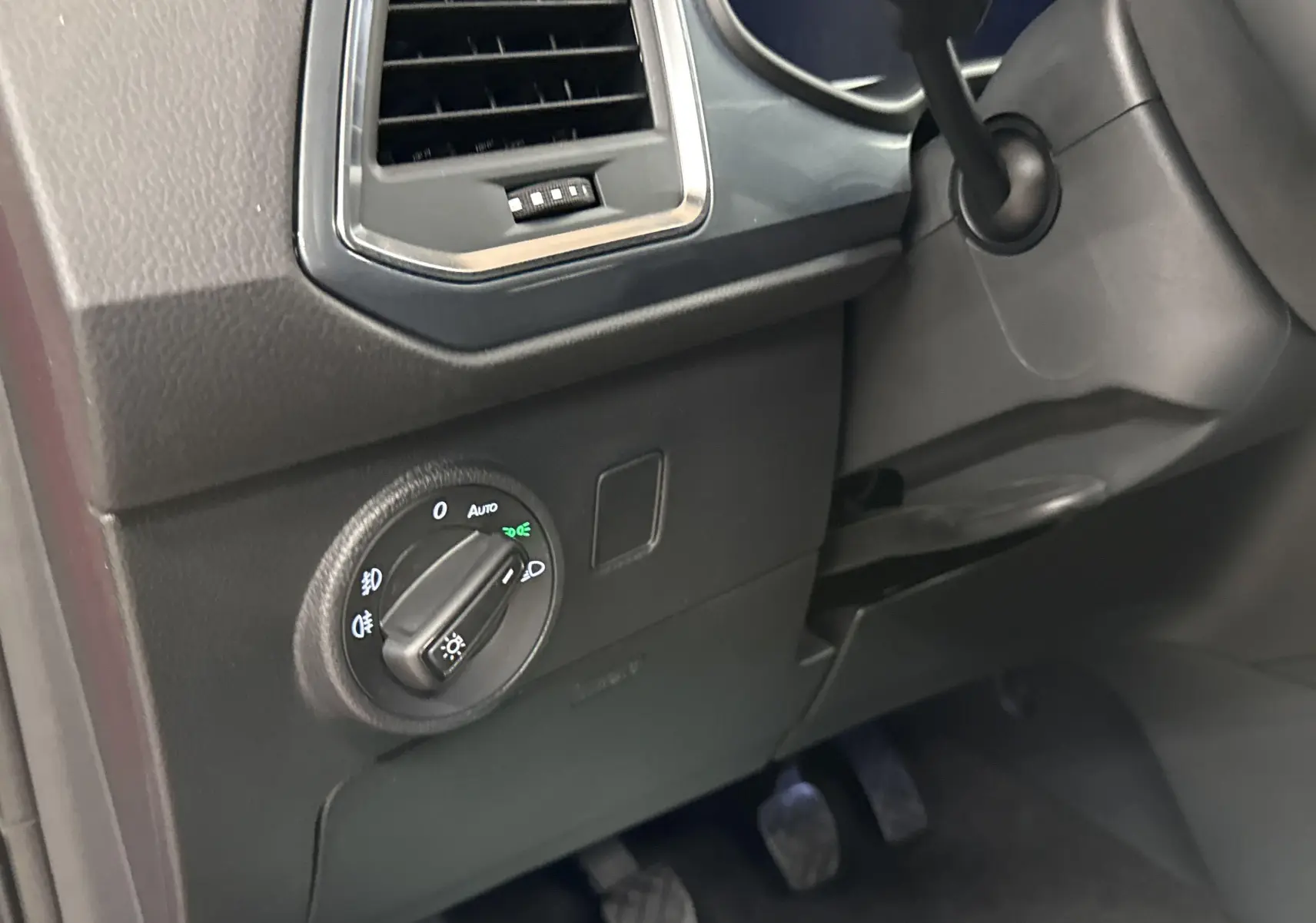 Détail du tableau de bord côté gauche du SEAT Ateca Rouge Velvet 2024, avec commande des phares et ventilation.