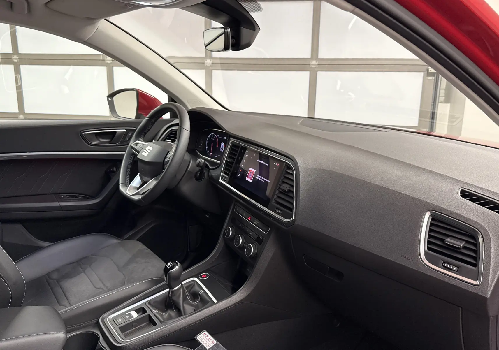 Intérieur du SEAT Ateca 2024 vu côté conducteur, avec tableau de bord noir et levier de vitesse manuel.