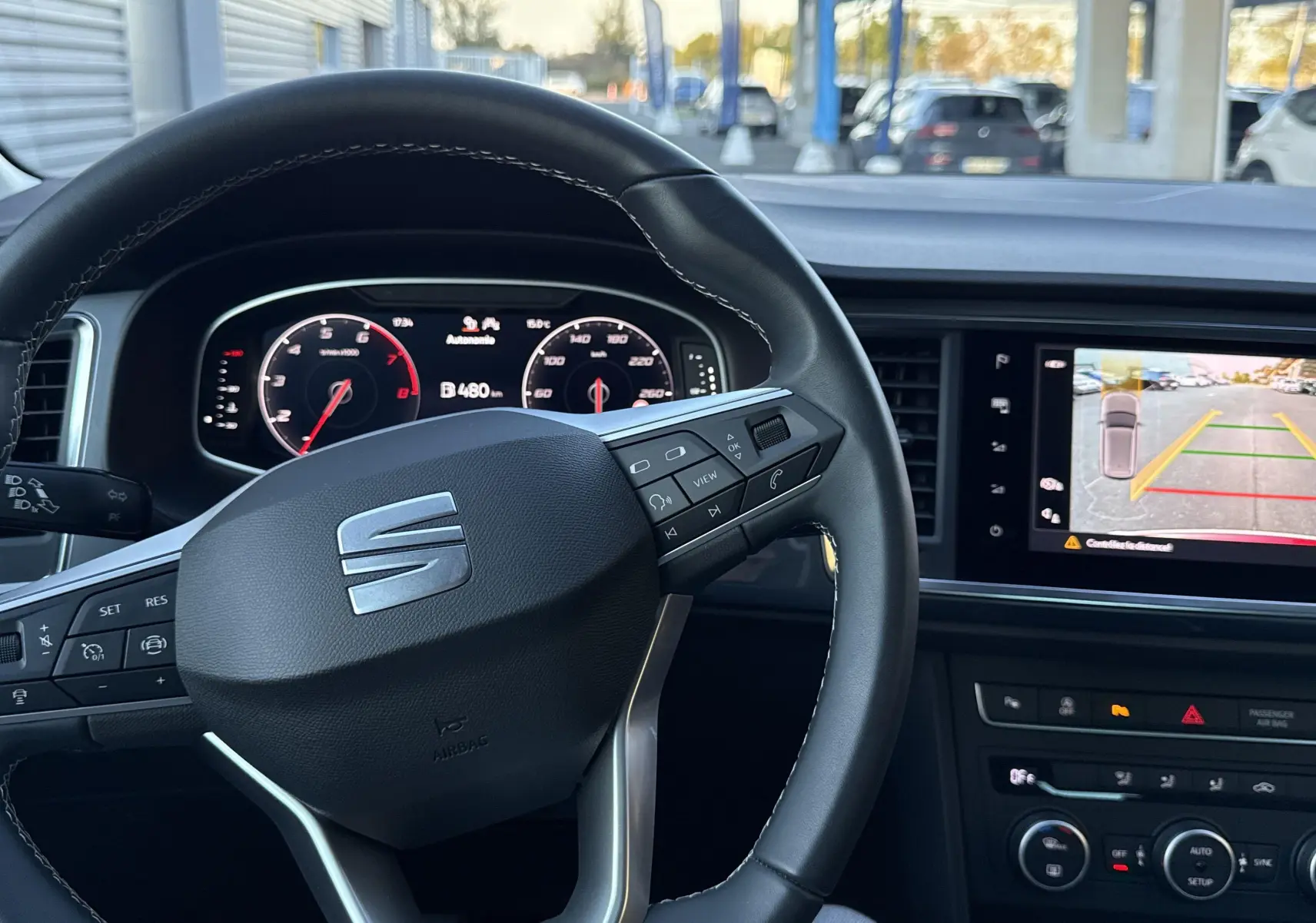 Intérieur du SEAT Ateca 2024 avec volant multifonction et écran de recul affichant la caméra de stationnement.