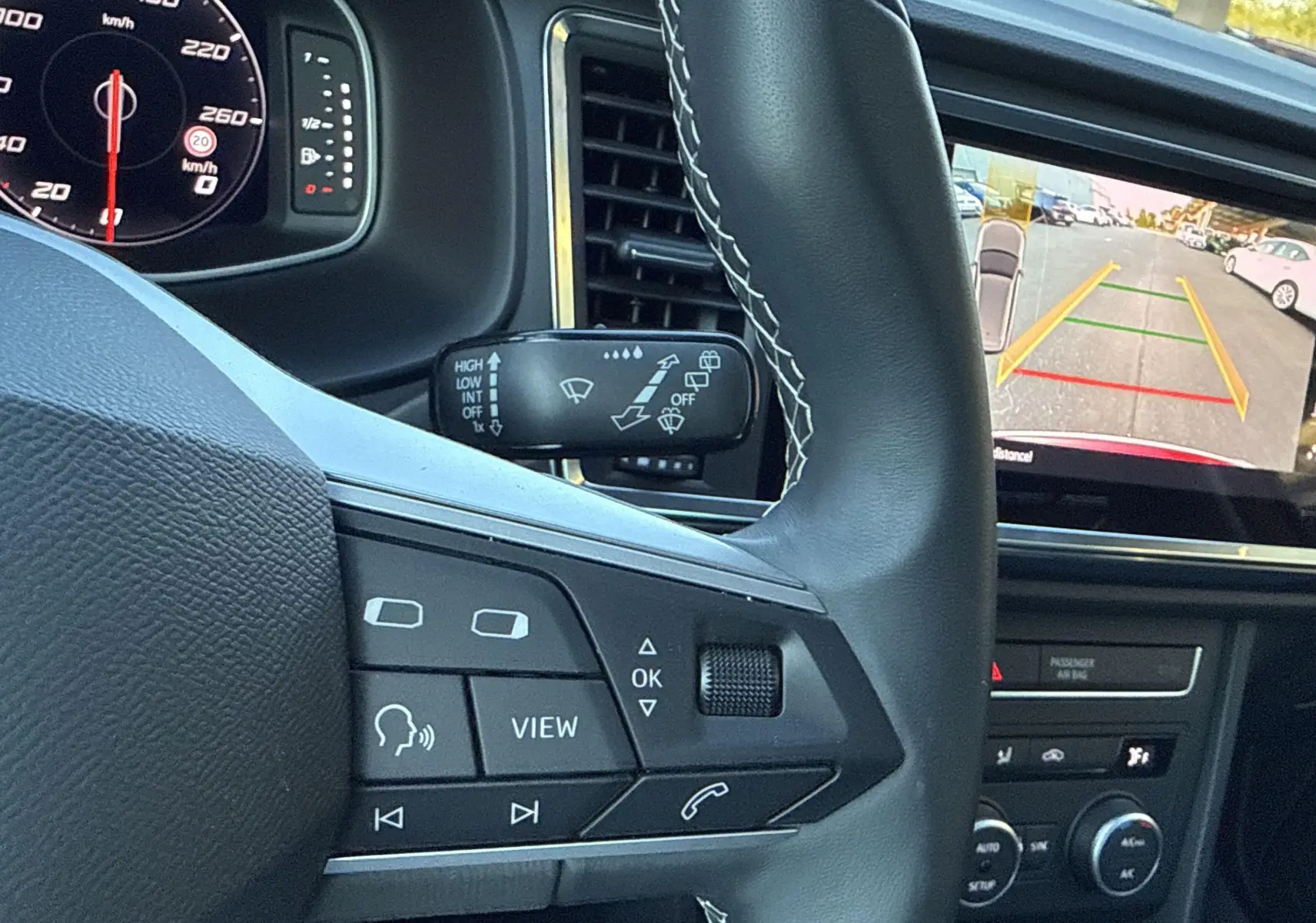 Vue rapprochée du volant et tableau de bord du SEAT Ateca 2024, avec écran de caméra de recul affiché.