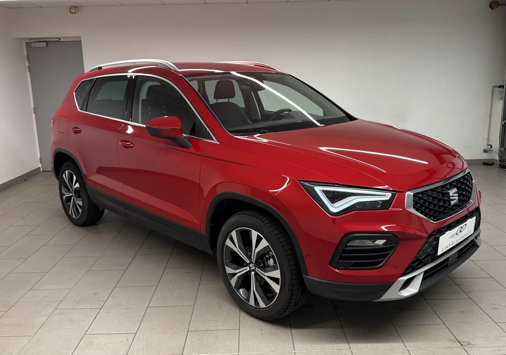 SEAT Ateca Rouge Velvet 2024 en 3/4 avant droit, mettant en valeur sa calandre et ses jantes alliage noires et argentées.