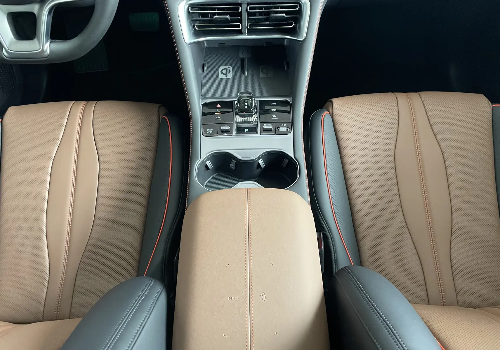 Vue plongeante sur la console centrale et les sièges avant en similicuir vegan marron et noir avec surpiqûres orange du BYD SEAL U.