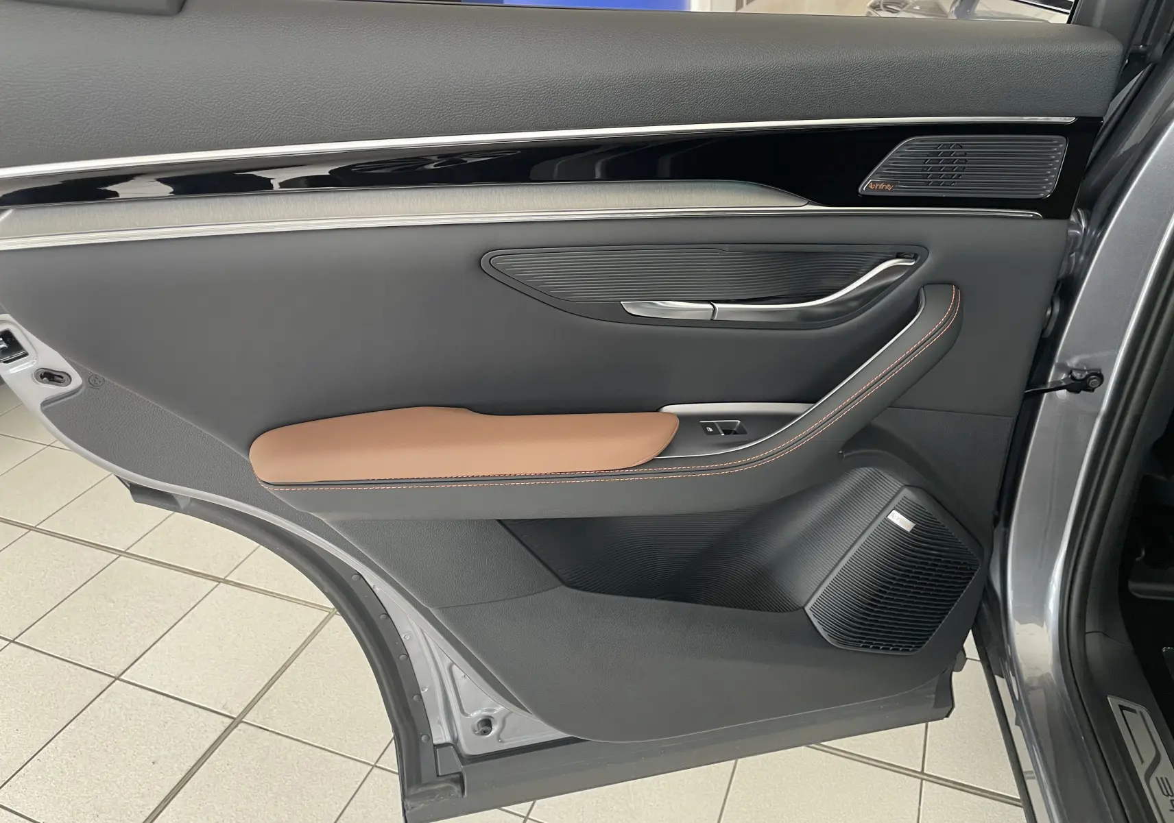 Vue intérieure de la porte arrière droite du BYD SEAL U 2026 TIME GREY, avec garniture noire et accoudoir marron.