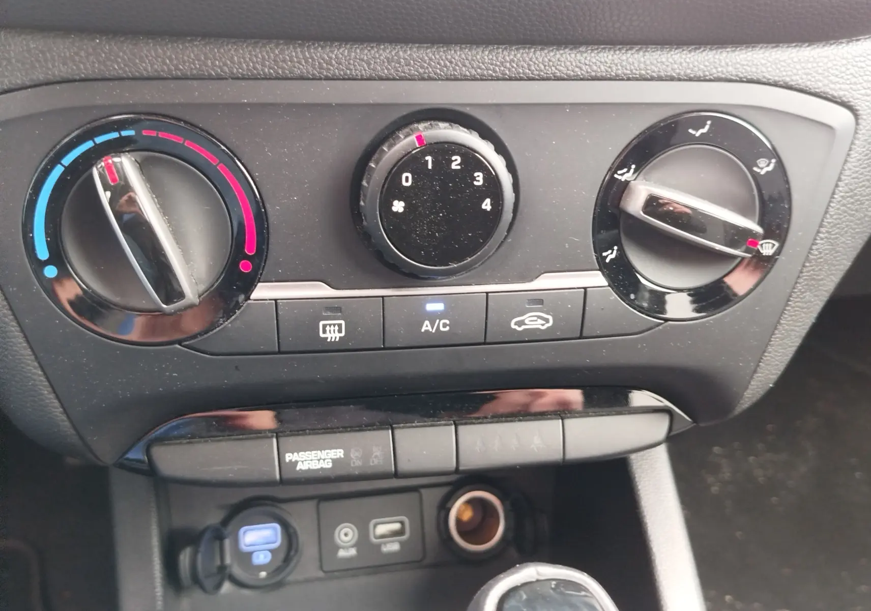 Vue rapprochée des commandes de climatisation et connectiques USB/AUX dans une Hyundai i20 2018 couleur Sleek Silver Métal.