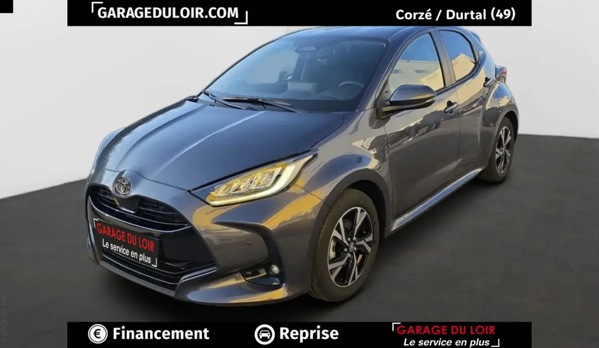 Toyota Yaris Hybride 116h Design gris foncé vue 3/4 avant avec phares LED et jantes alliage noires.