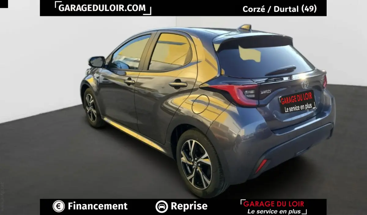 Vue 3/4 arrière droite d'une Toyota Yaris hybride 116h Design gris foncé avec jantes alliage et feux LED distinctifs.
