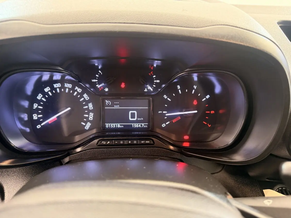 Vue rapprochée du tableau de bord du Citroën Berlingo blanc 2022, affichant compteur et écran digital.