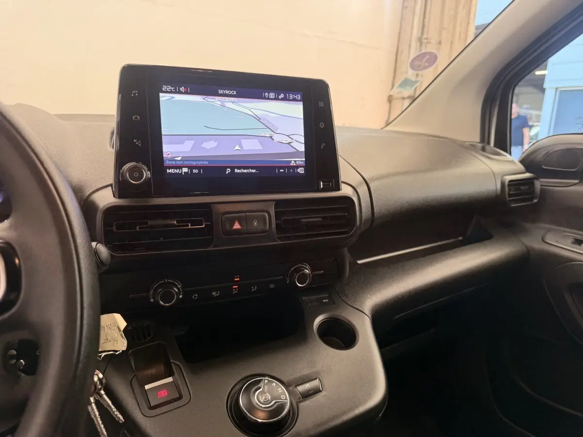 Vue intérieure côté conducteur du tableau de bord noir du Citroën Berlingo 2022 avec écran tactile et commande de boîte automatique.
