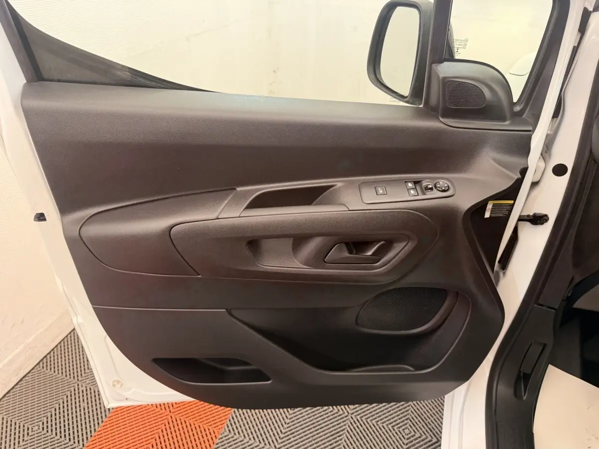 Vue rapprochée de la porte avant gauche noire du Citroën Berlingo blanc 2022 avec commandes électriques.
