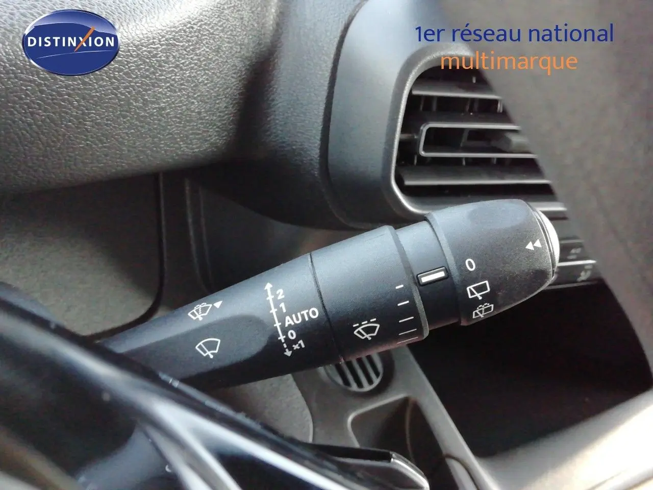 Gros plan sur la commande d’essuie-glace à gauche du volant du Peugeot Partner blanc Kaolin, intérieur noir.