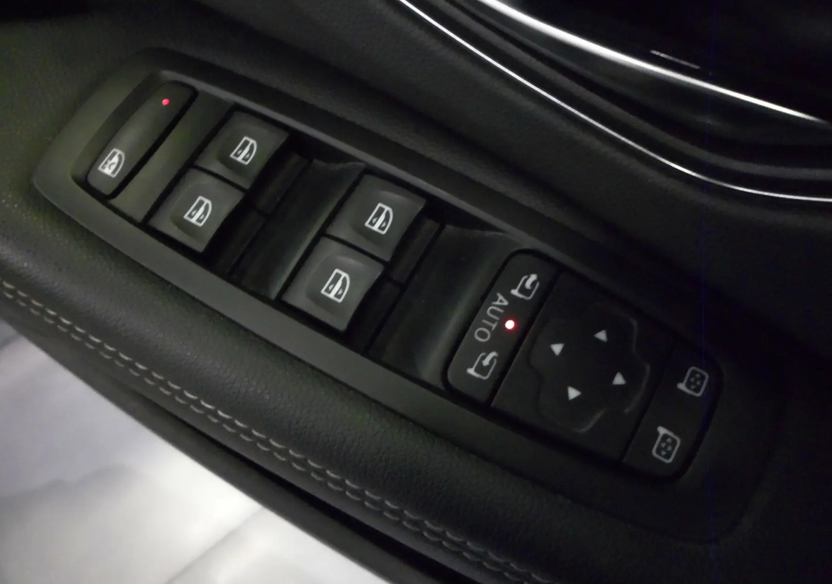 Gros plan sur les commandes de lève-vitres et rétroviseurs côté conducteur du Renault Grand Scenic IV blanc Glacier.