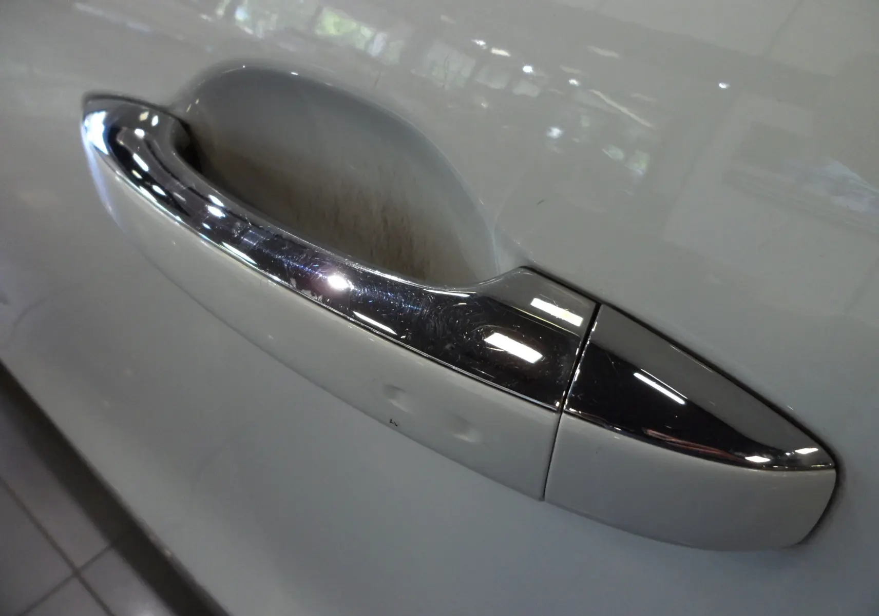 Poignée de porte chromée sur la portière blanche glacier d'un Renault Grand Scenic IV Blue dCi 120 CH BUSINESS 2019.