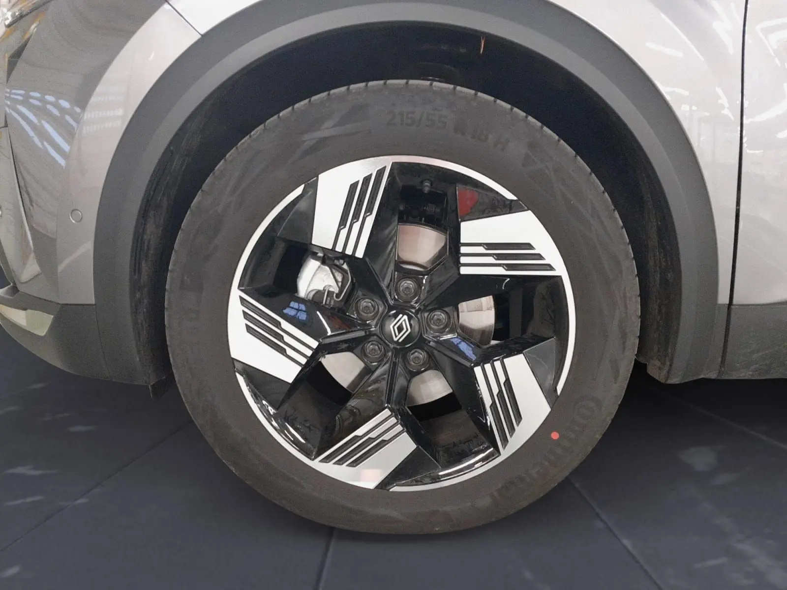 Gros plan sur la jante alliage 18'' diamantée noire et argent du Renault Symbioz gris Casiopee, roue avant droite.