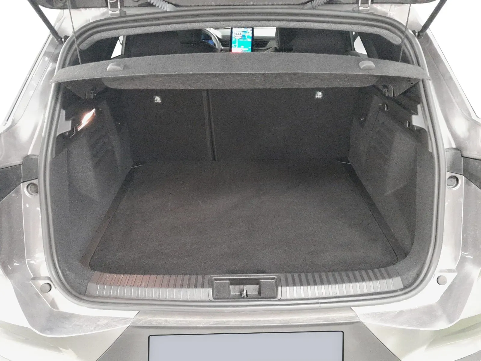 Coffre ouvert vu de l'arrière d'une Renault Symbioz gris Casiopee, montrant l'espace de rangement vide et la tablette arrière.