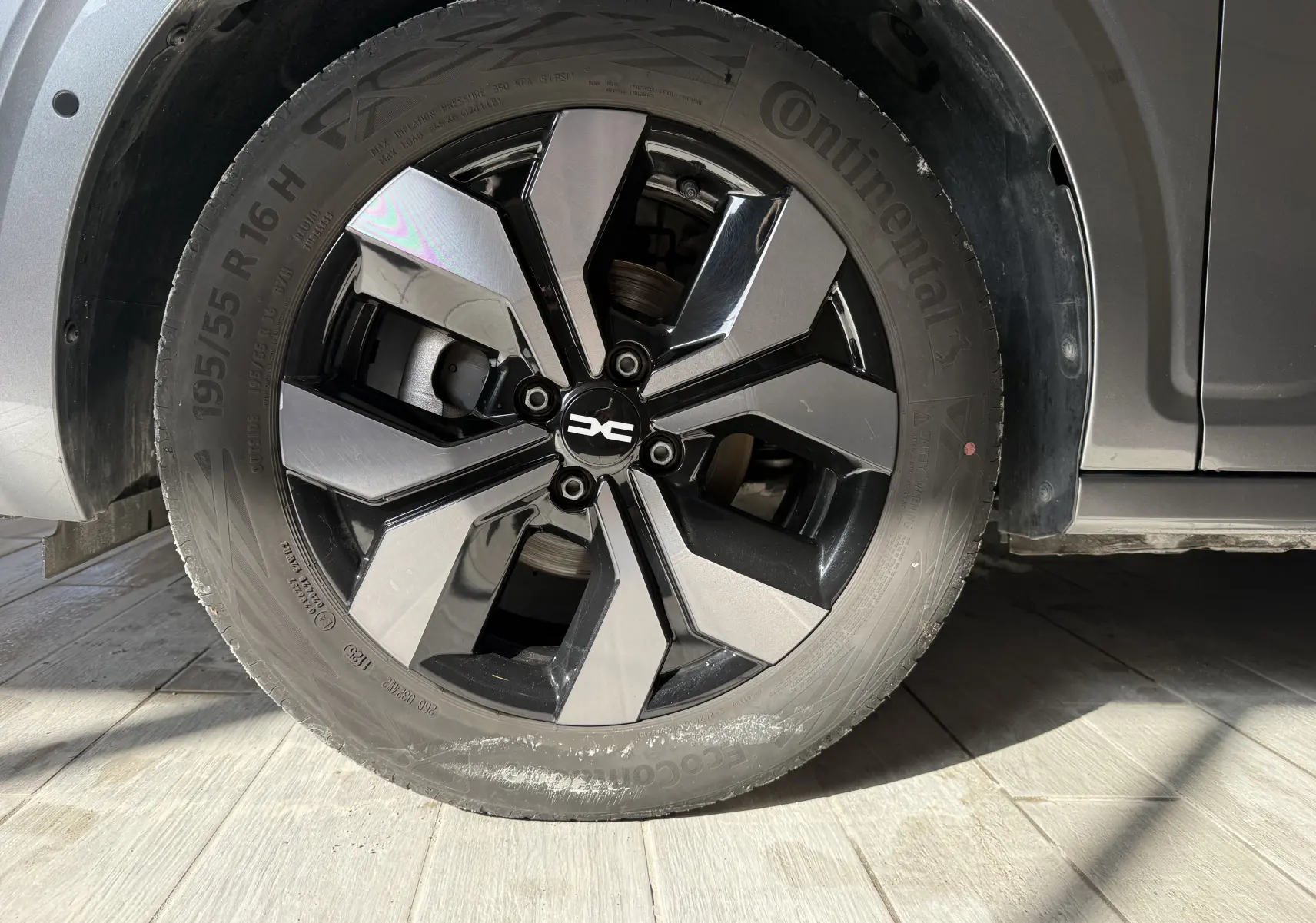 Gros plan sur la roue avant gauche gris métallisé de la Dacia Sandero 2025 avec jante alliage bicolore moderne.