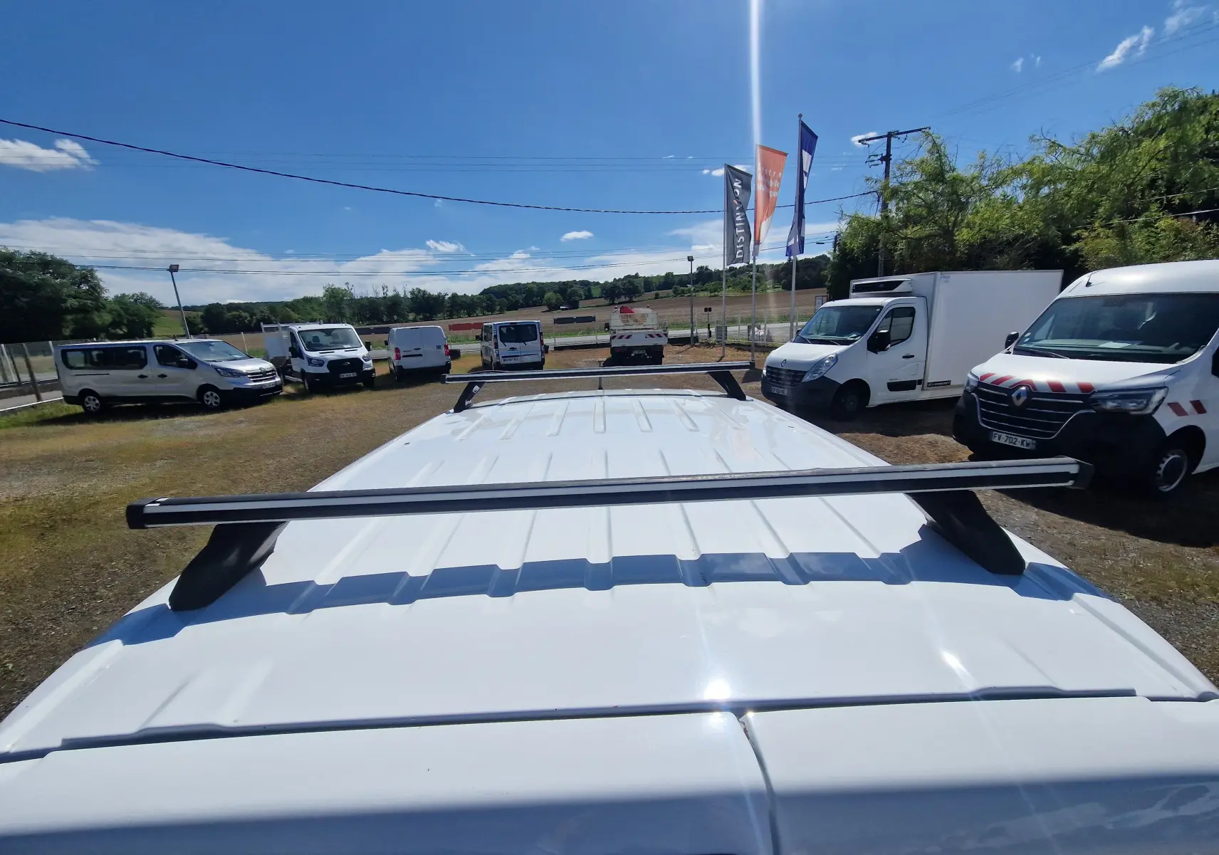 Vue plongeante sur le toit blanc d’un Citroën Berlingo M 1.5 BlueHDi 100 avec barres de toit noires, en extérieur.