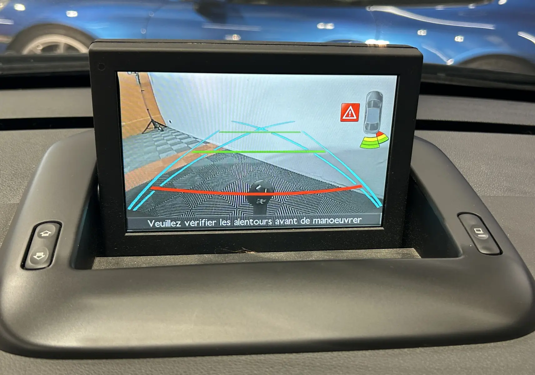 Écran de caméra de recul du Peugeot 3008 gris montrant les lignes d’aide au stationnement et l’attelage arrière.