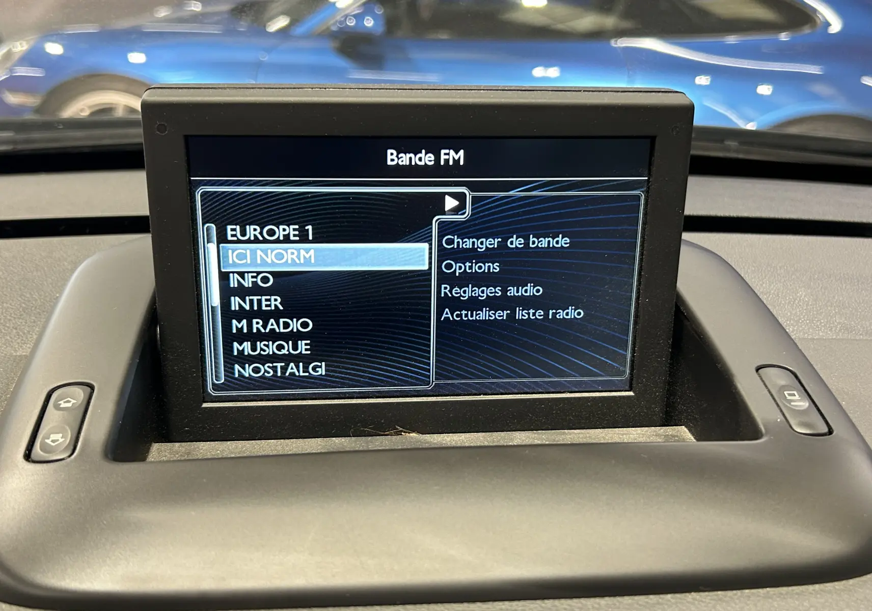 Écran central du tableau de bord affichant les options de radio FM dans une Peugeot 3008 gris, vue intérieure frontale.