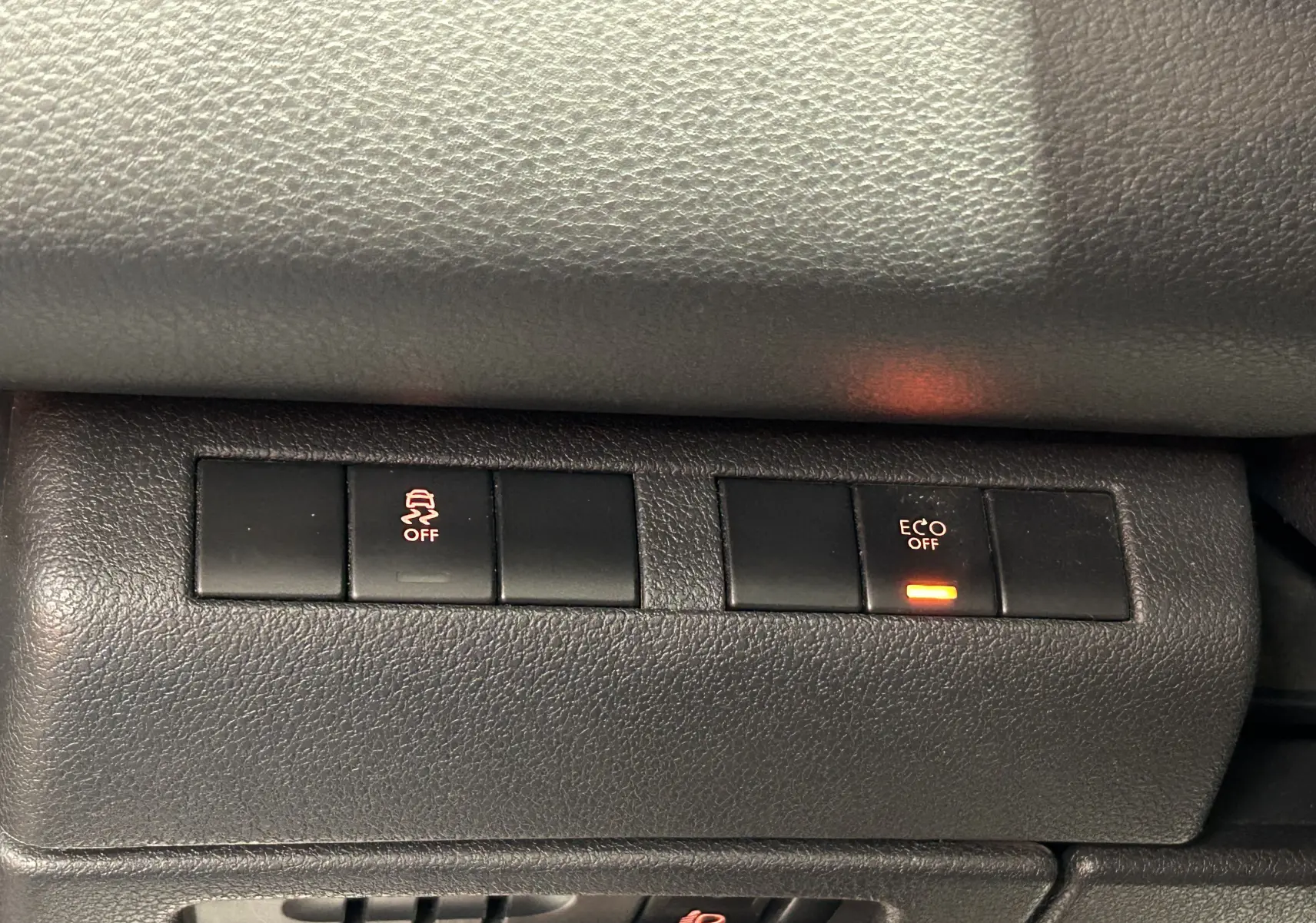 Gros plan sur les boutons de commande intérieurs du tableau de bord du Peugeot 3008 gris, avec voyants Eco et contrôle de stabilité désactivés.