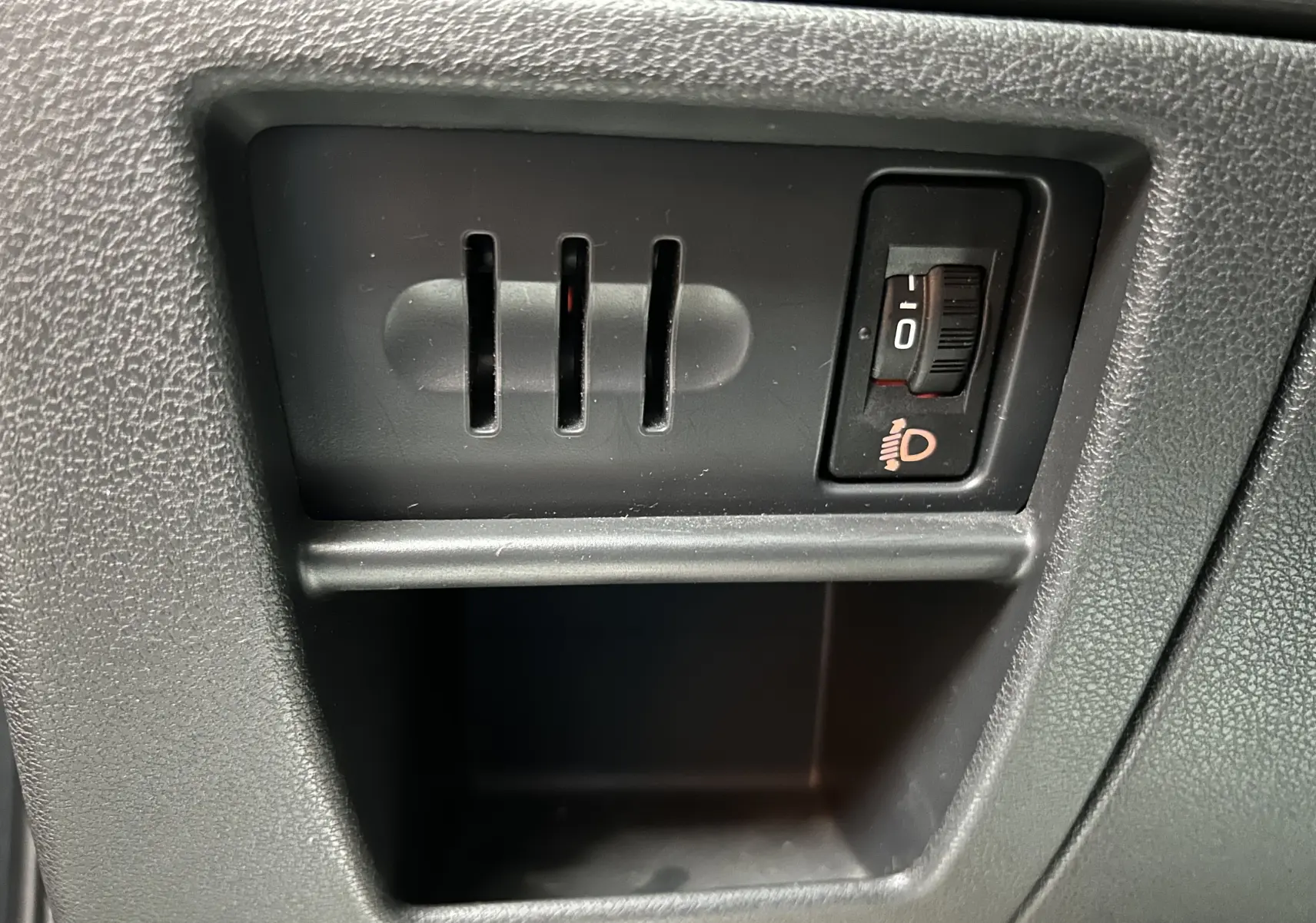Gros plan sur le réglage d'inclinaison des phares dans l'habitacle du Peugeot 3008 gris.