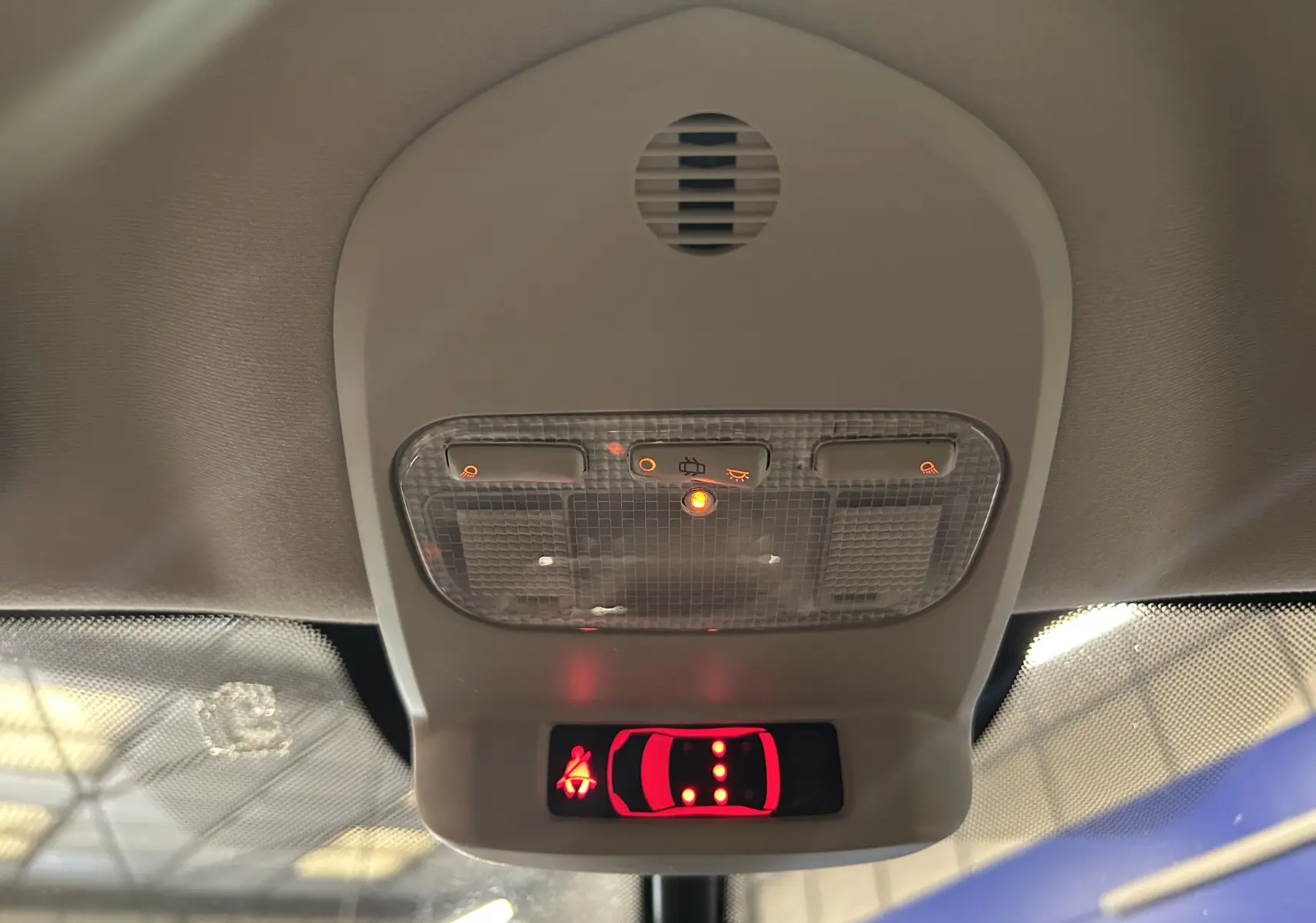 Vue intérieure du plafonnier avant avec commandes d’éclairage et indicateur de ceinture allumée sur Peugeot 3008 gris.
