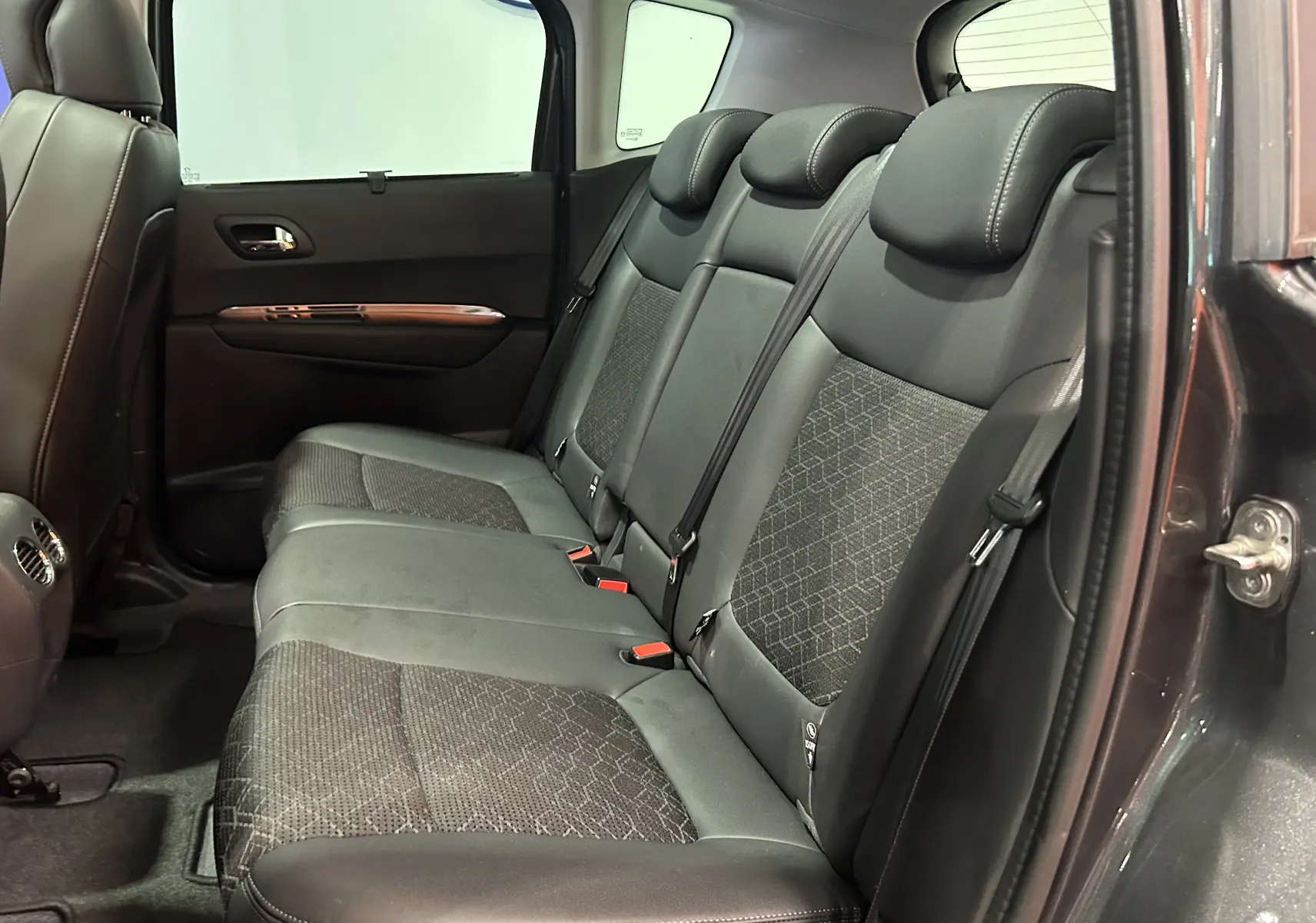 Vue intérieure côté droit des sièges arrière en tissu et cuir du Peugeot 3008 gris, montrant l'espace et les ceintures de sécurité.