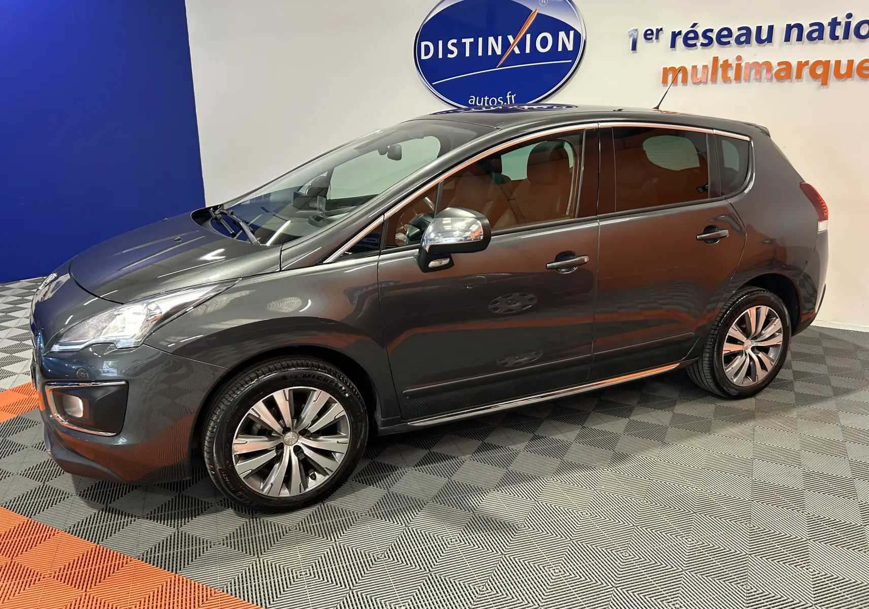 Vue latérale droite d'un Peugeot 3008 gris métallisé en intérieur, soulignant ses jantes alliage et ses vitres teintées.
