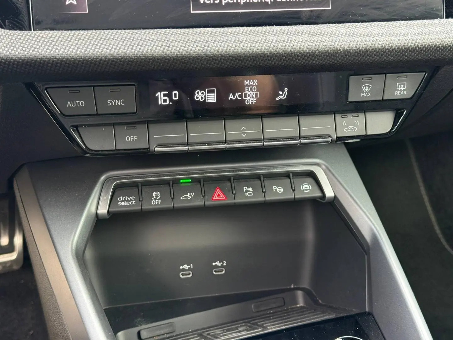 Vue rapprochée de la console centrale de l'Audi A3 Sportback 2025, avec commandes clim et ports USB visibles.