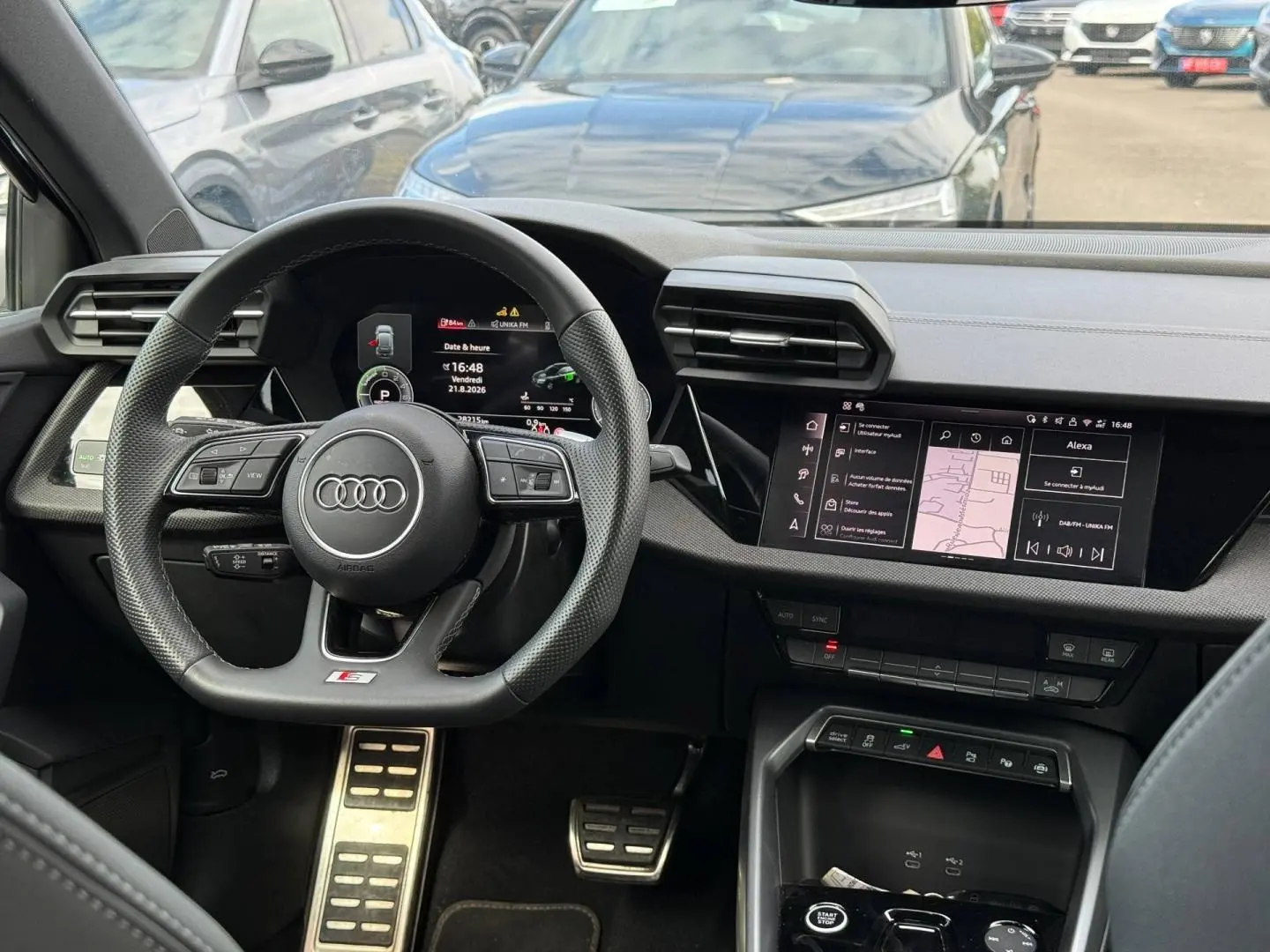 Vue intérieure centrée sur le volant sport et le tableau de bord numérique de l'Audi A3 Sportback 2025.
