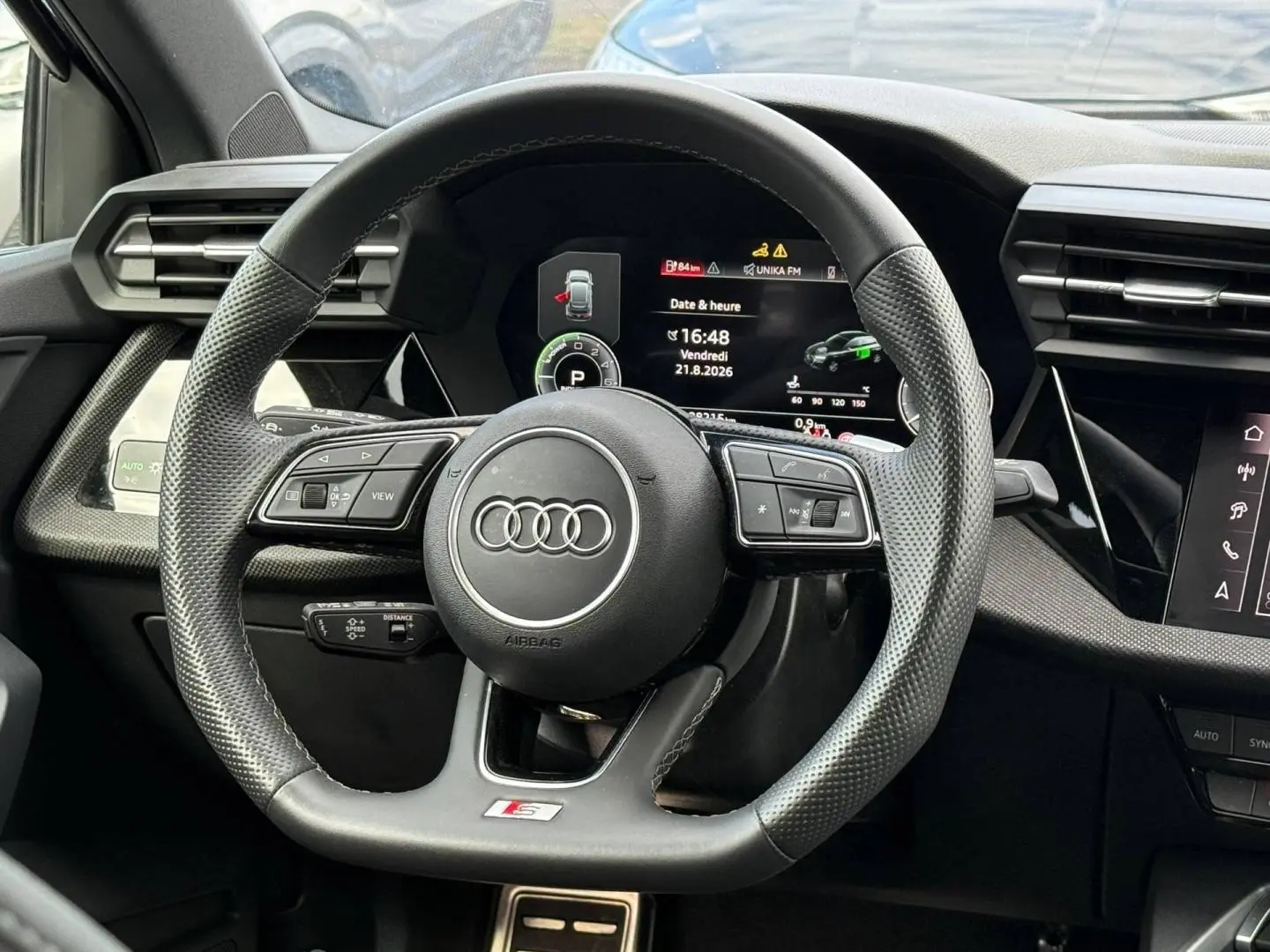 Vue rapprochée du volant sport Audi A3 Sportback 1.5 TFSI e 204ch S line avec tableau de bord numérique.