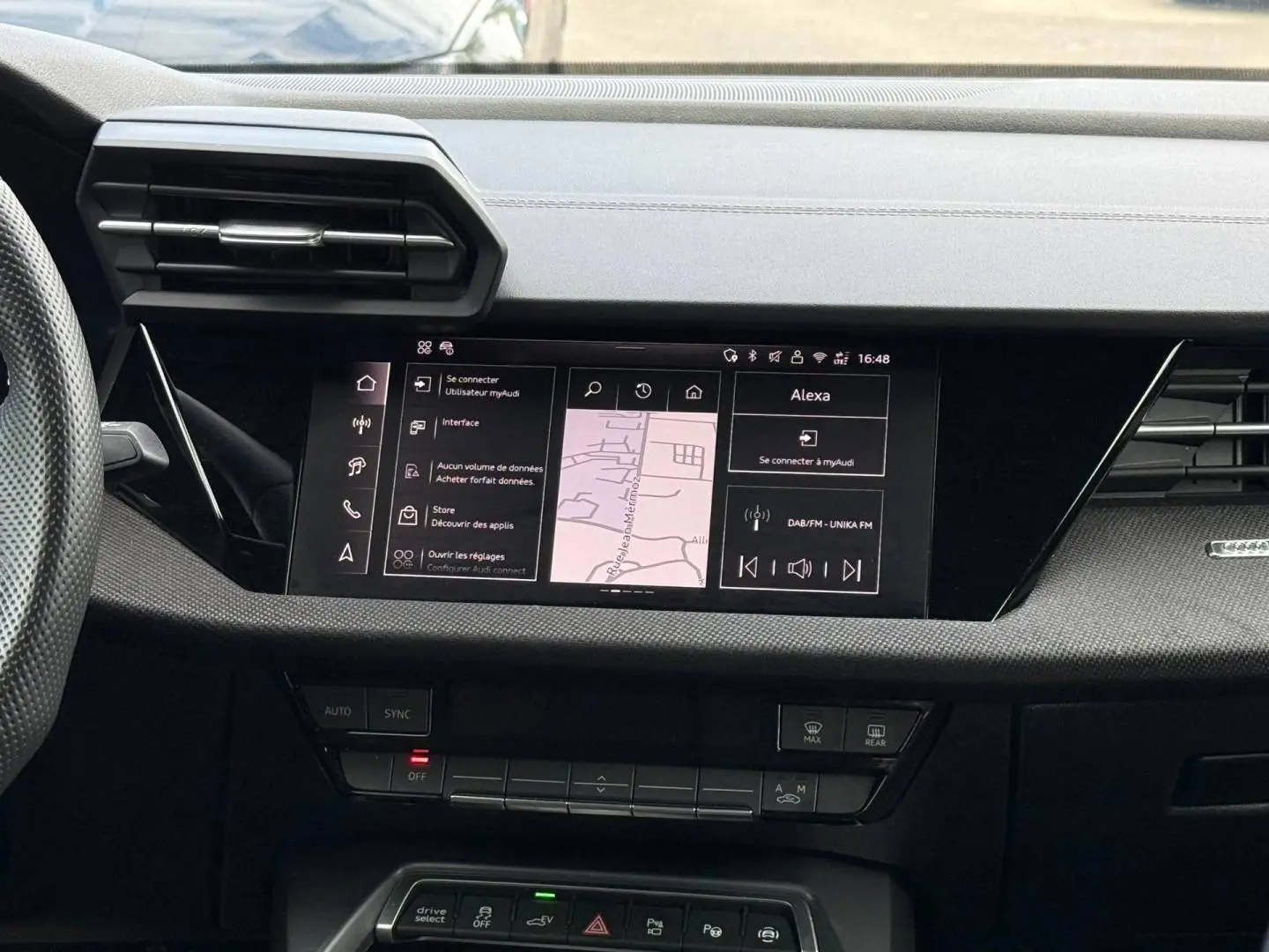 Vue rapprochée de la console centrale de l’Audi A3 Sportback 2025 avec écran tactile et commandes noires.