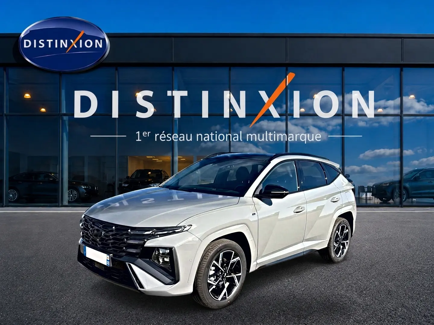 Hyundai Tucson 1.6 T-GDI hybride gris shadow en 3/4 avant droit, avec calandre noire et jantes alu distinctives.