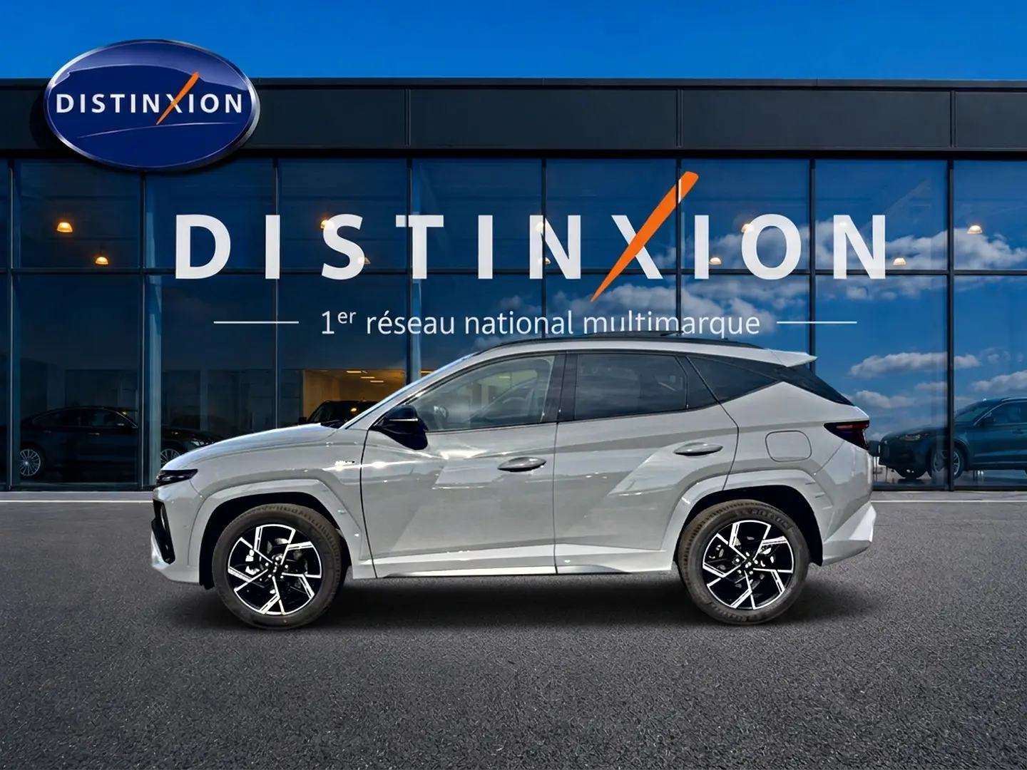 Hyundai Tucson 2026 gris shadow en profil droit, avec jantes alu noires et toit panoramique visible.