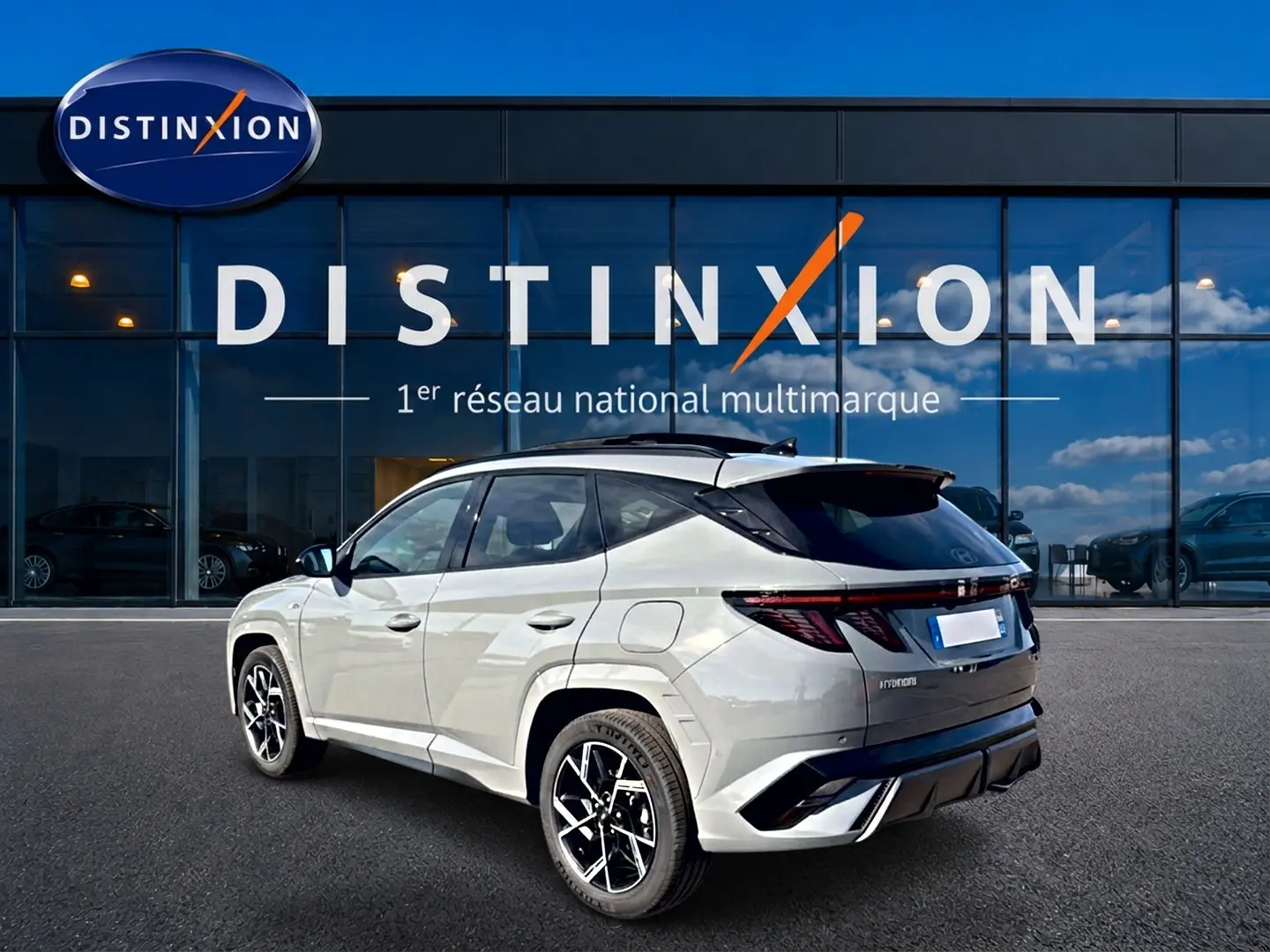 Vue 3/4 arrière droite du Hyundai Tucson 2026 gris shadow avec jantes alu et toit noir contrasté.