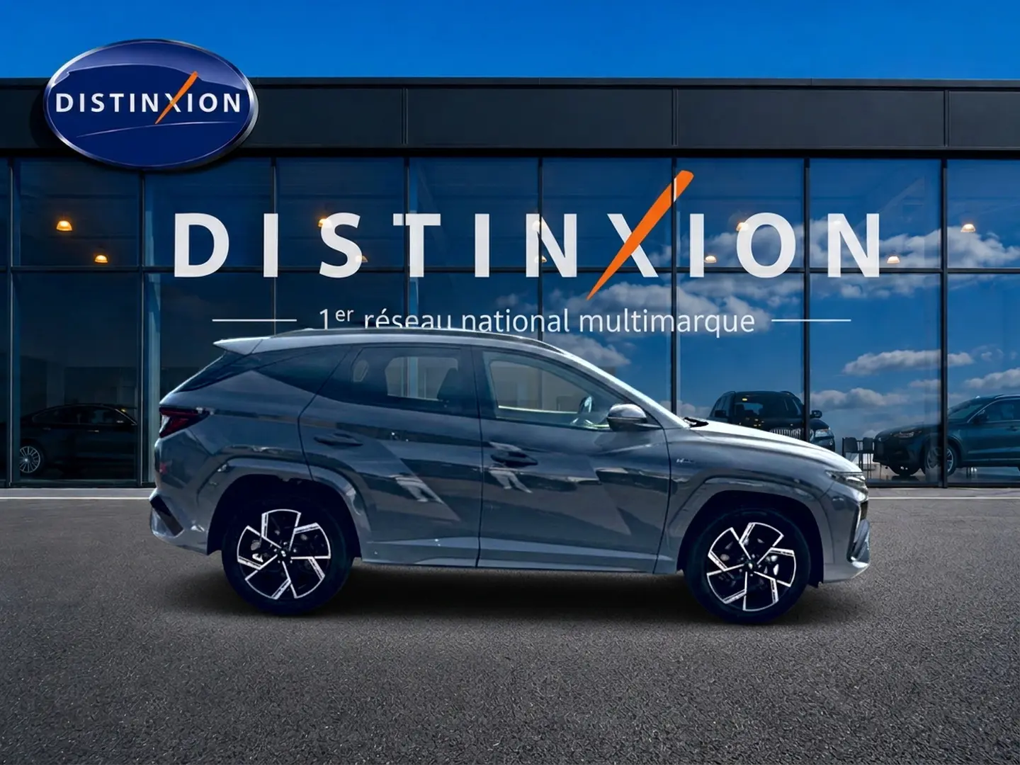 Hyundai Tucson 2026 gris shadow en profil gauche, avec jantes alu distinctives et toit panoramique visible.