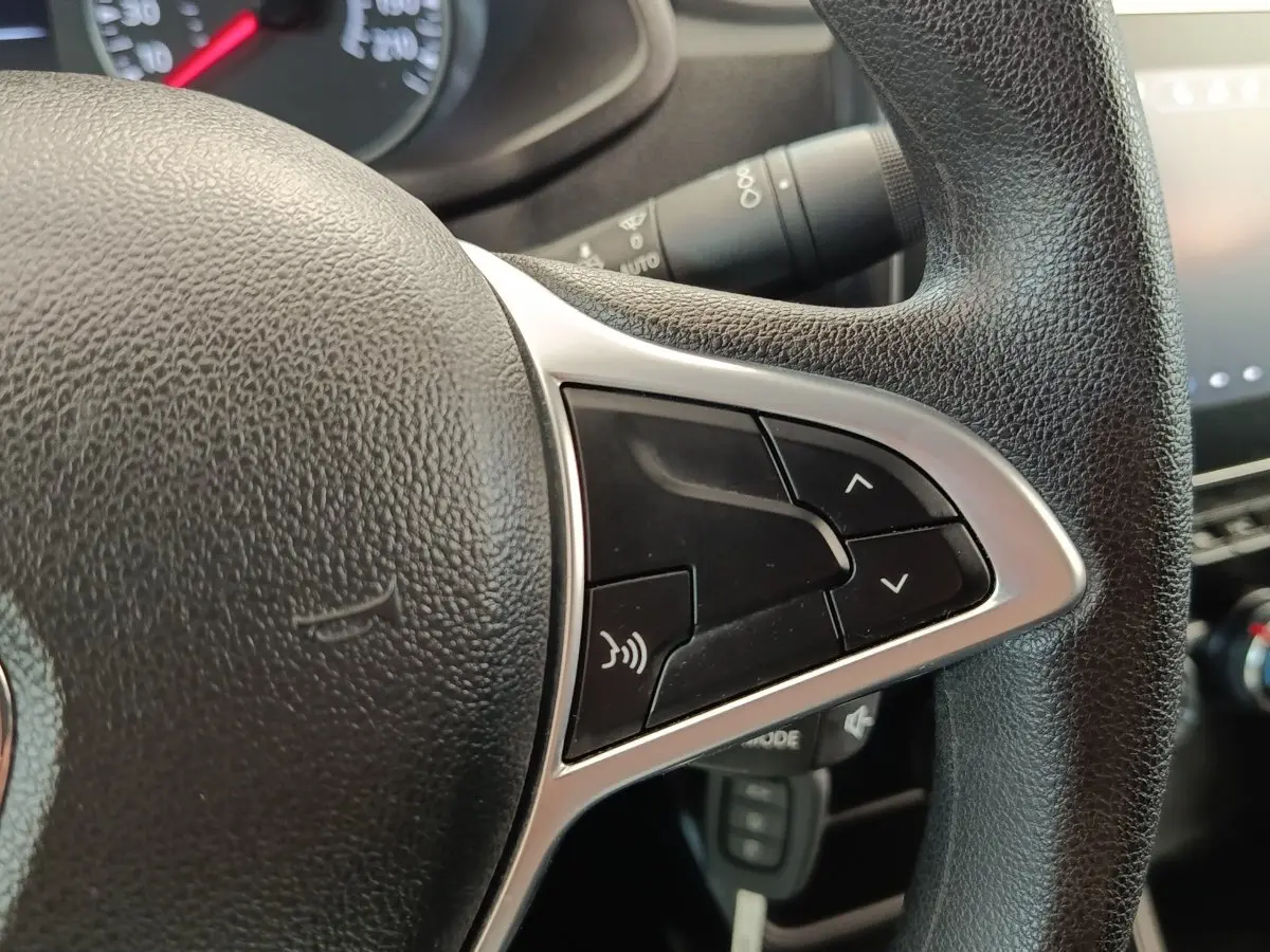 Gros plan sur le volant multifonctions noir du Renault Express 2023, avec commandes audio et finition argentée.