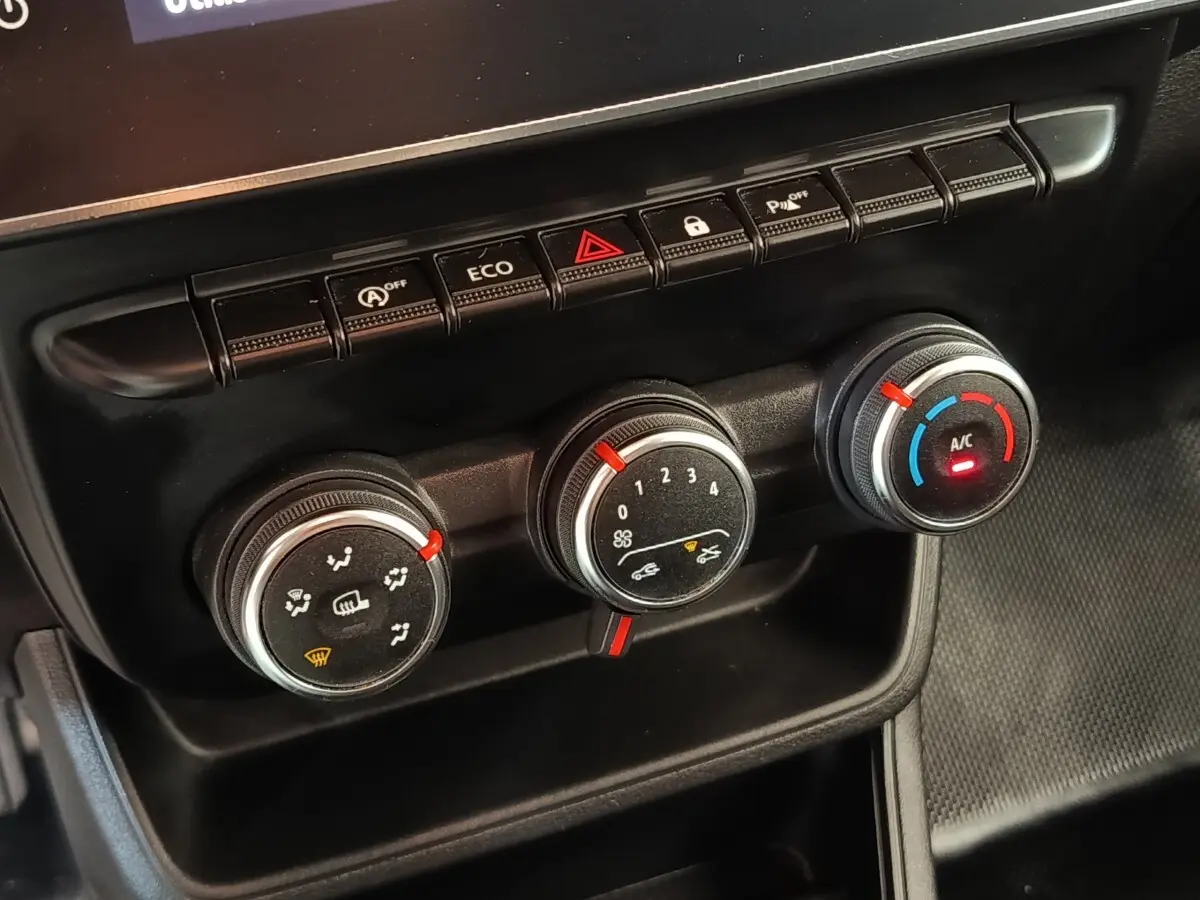 Gros plan sur les commandes de climatisation et boutons de fonction du tableau de bord du Renault Express blanc 2023.