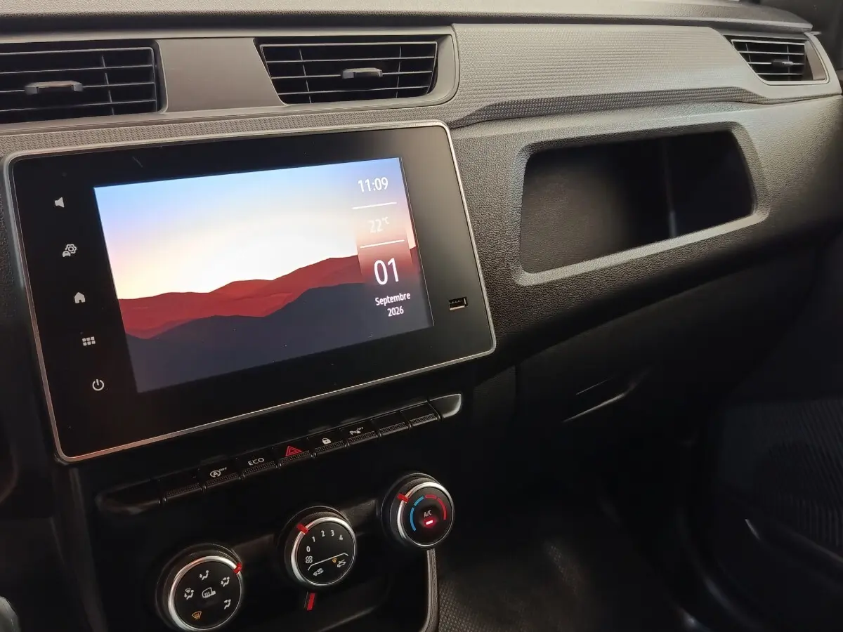 Vue intérieure du tableau de bord noir du Renault Express 2023 avec écran tactile et commandes de climatisation.